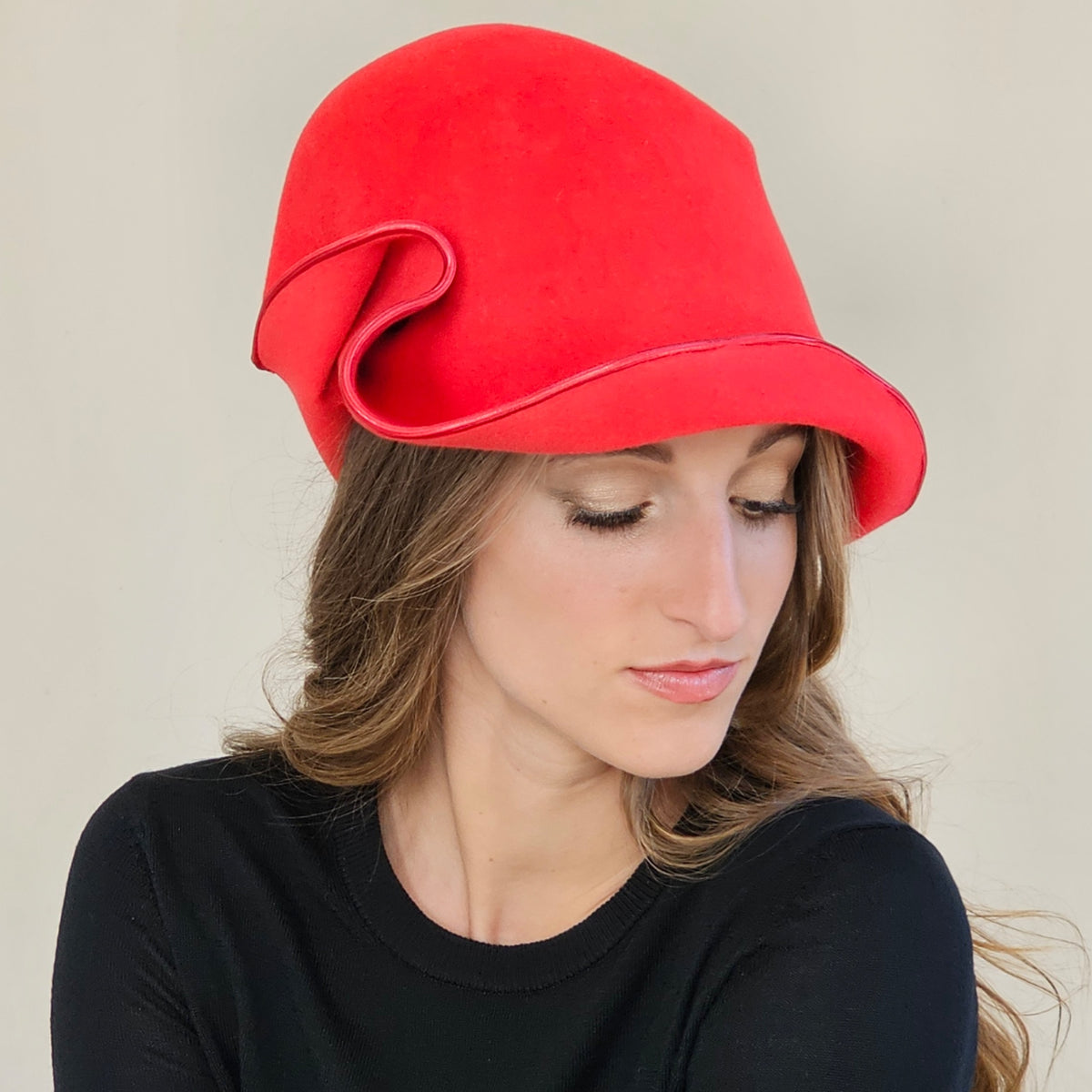 Angled close-up of red felt cloche showing curled brim and metallic
edging
