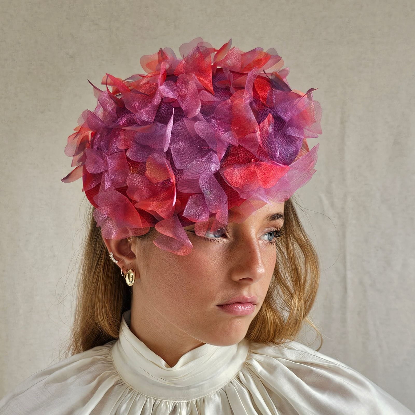 Red, lilac and organza beret with beautiful petal embellishments, angle view.