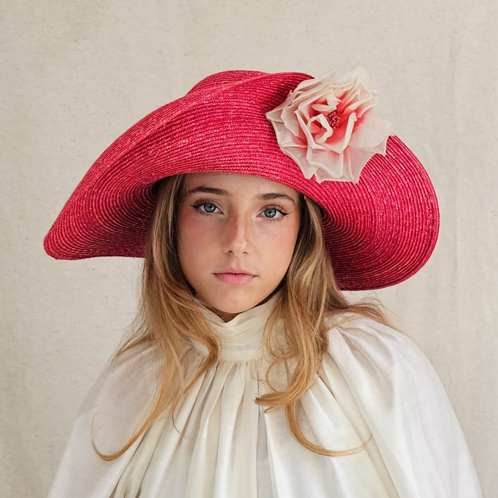 Red straw sunhat with beautiful flower embellishment, front view.