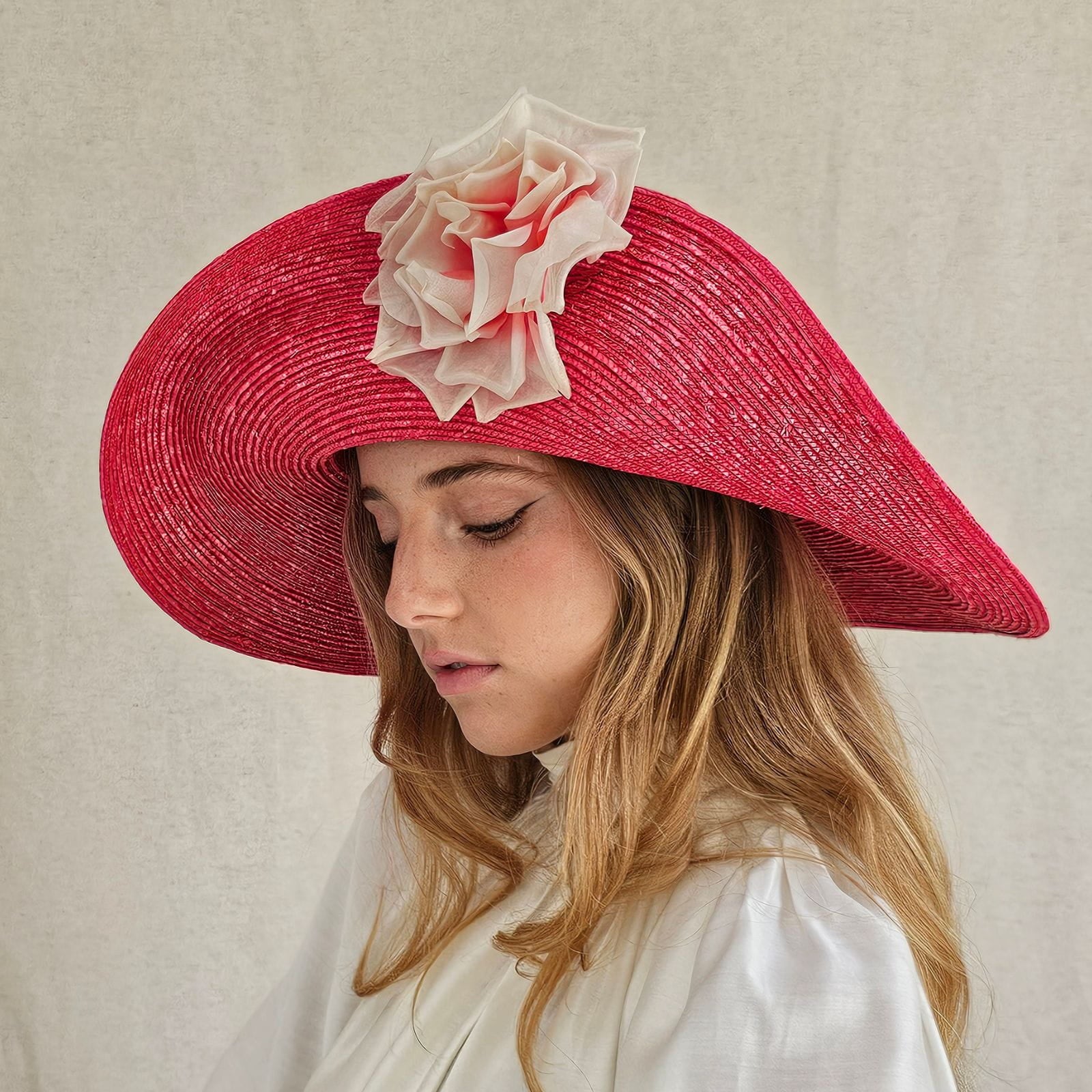 Red straw sunhat with beautiful flower embellishment, side view.