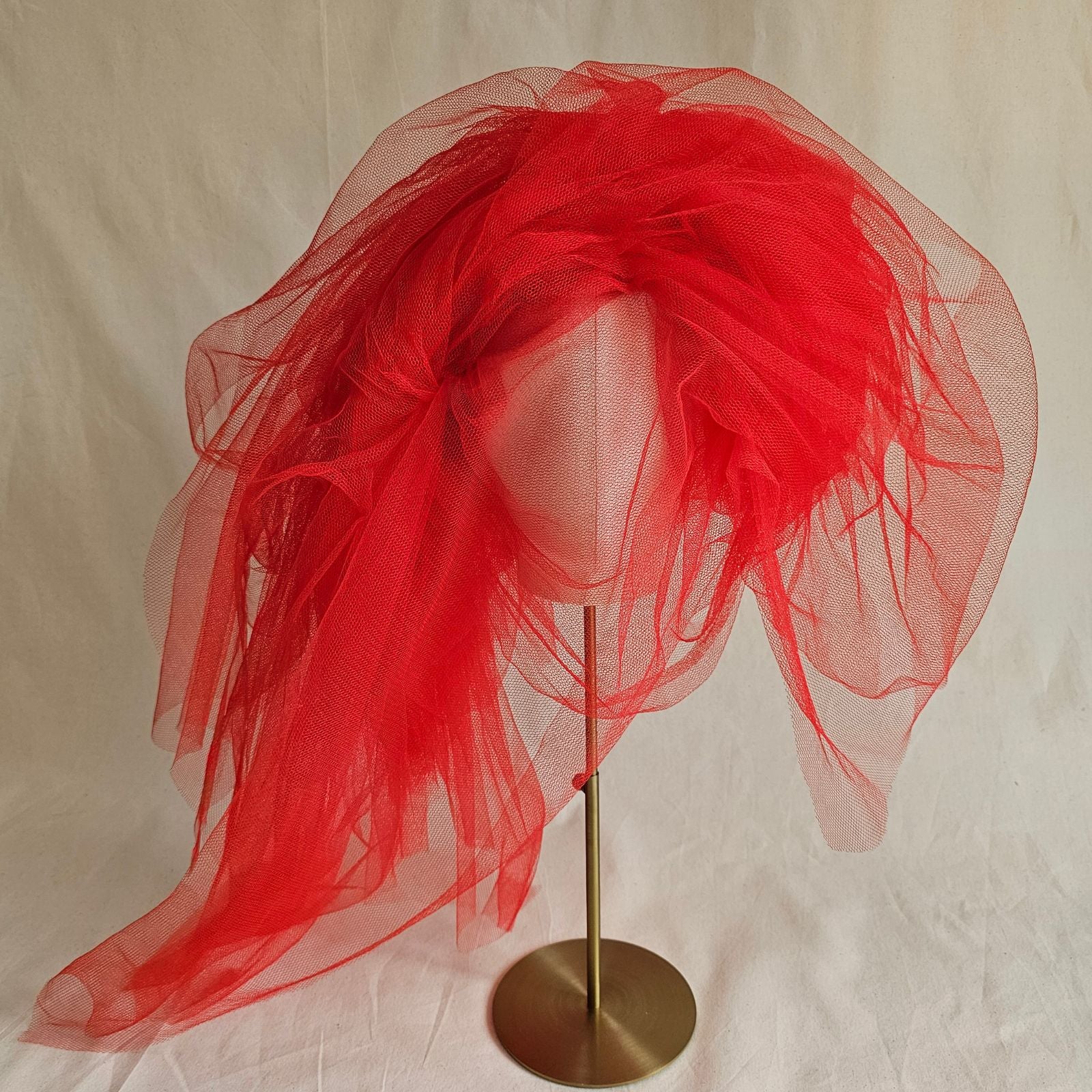 Red tulle veiled statement hat, front view.