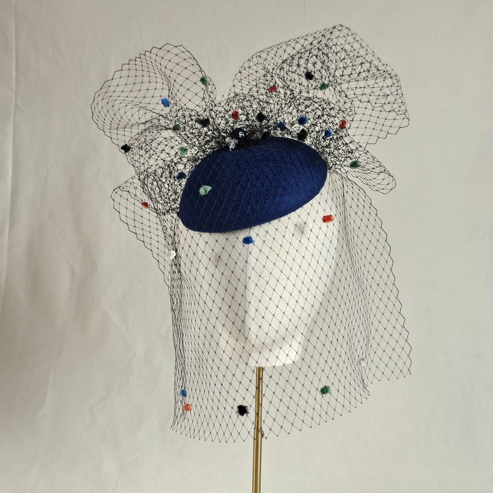 Royal blue felt beret with multicolour dot veiling, front view.
