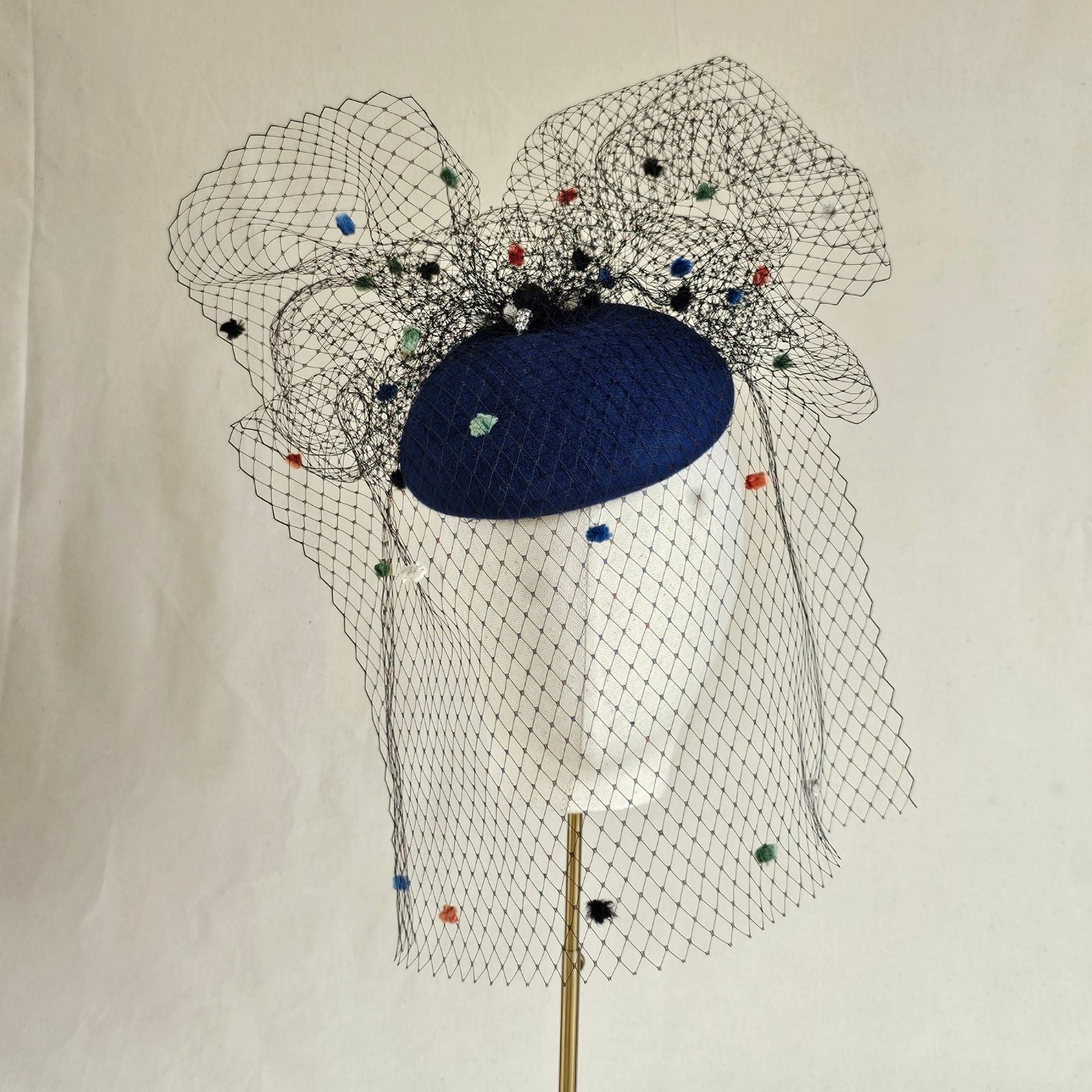 Royal blue felt beret with multicolour dot veiling, front view.