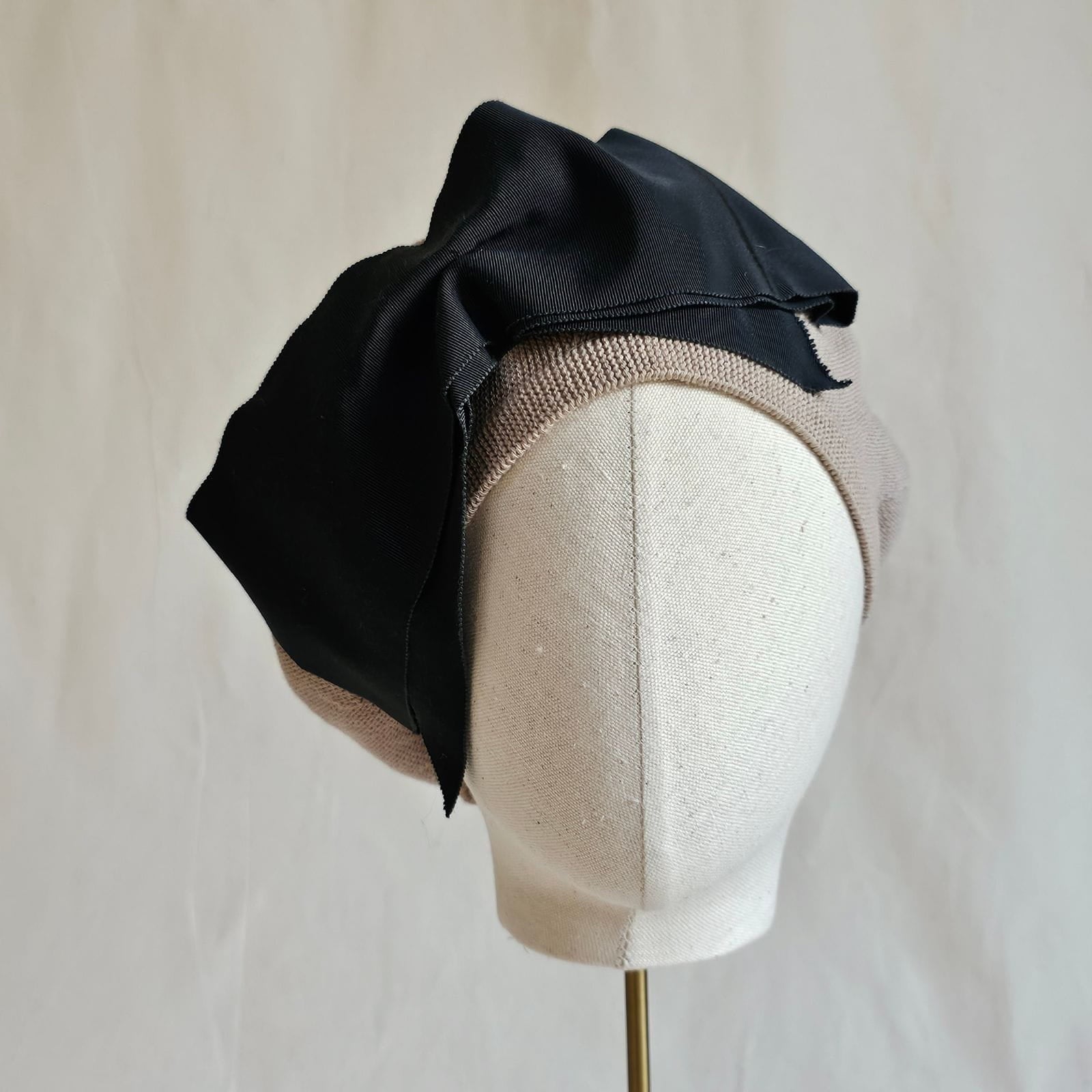 Taup cotton beret with dramatic black bow, front view.