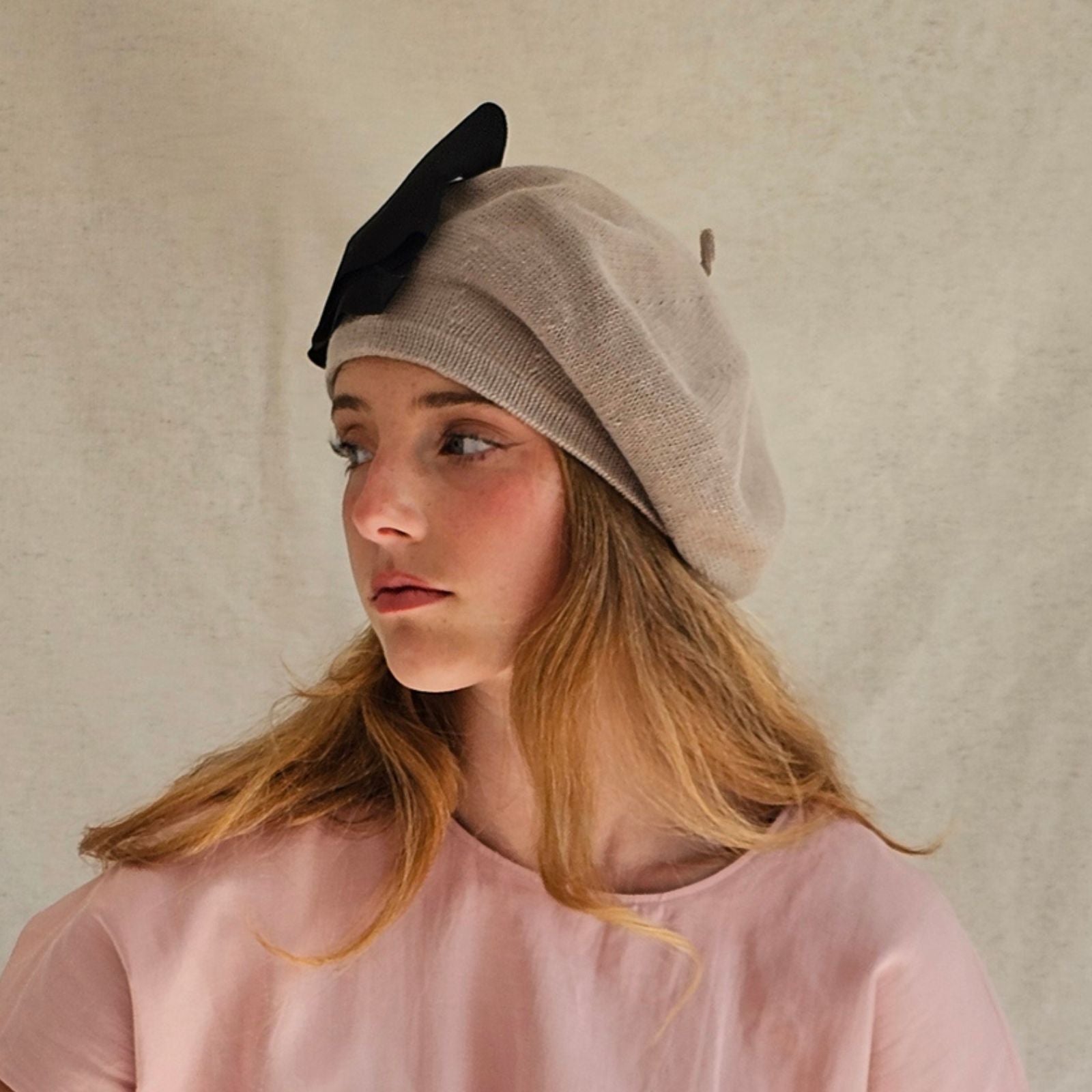 Taupe cotton beret with dramatic black bow, left view.