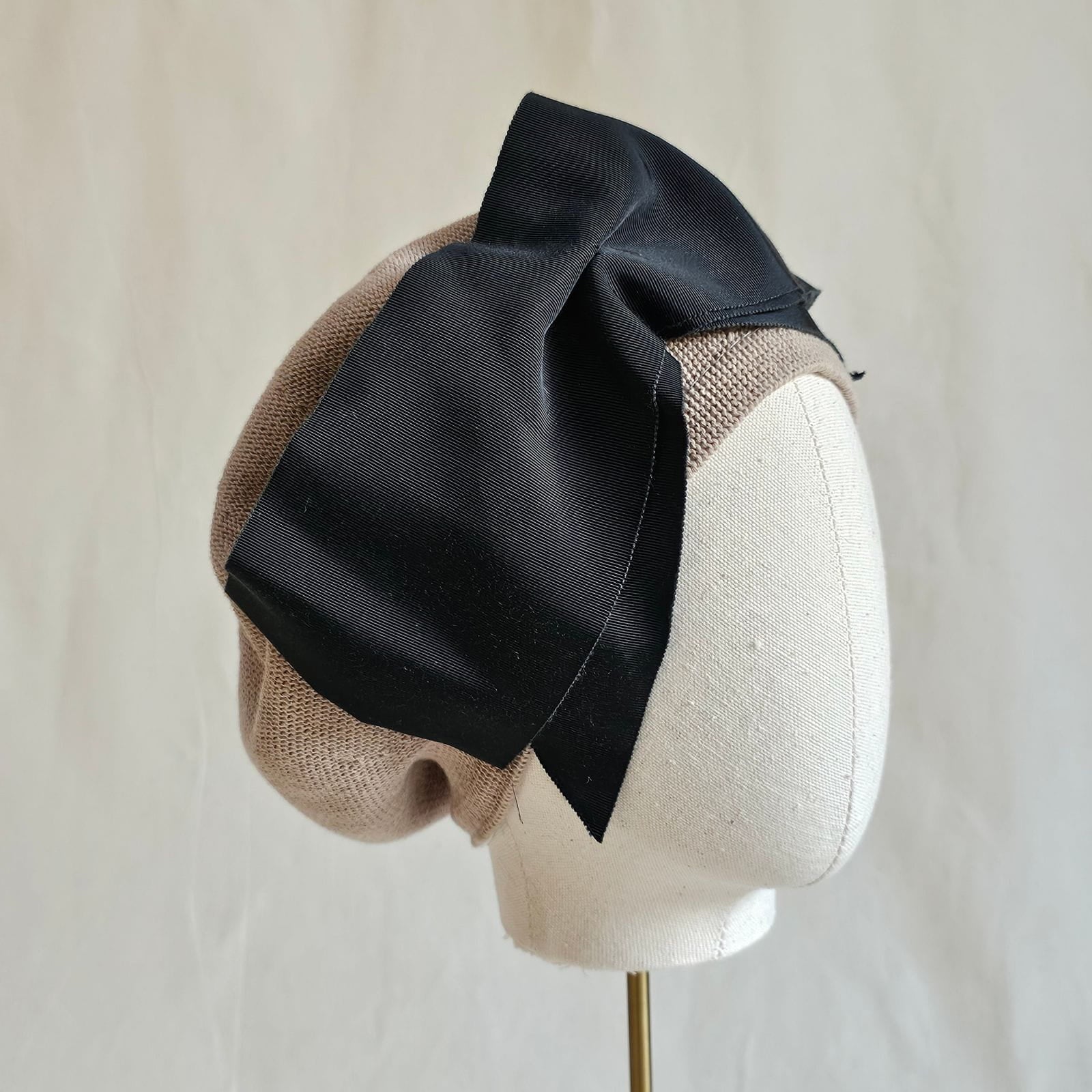 Taupe cotton beret with dramatic black bow, side view.