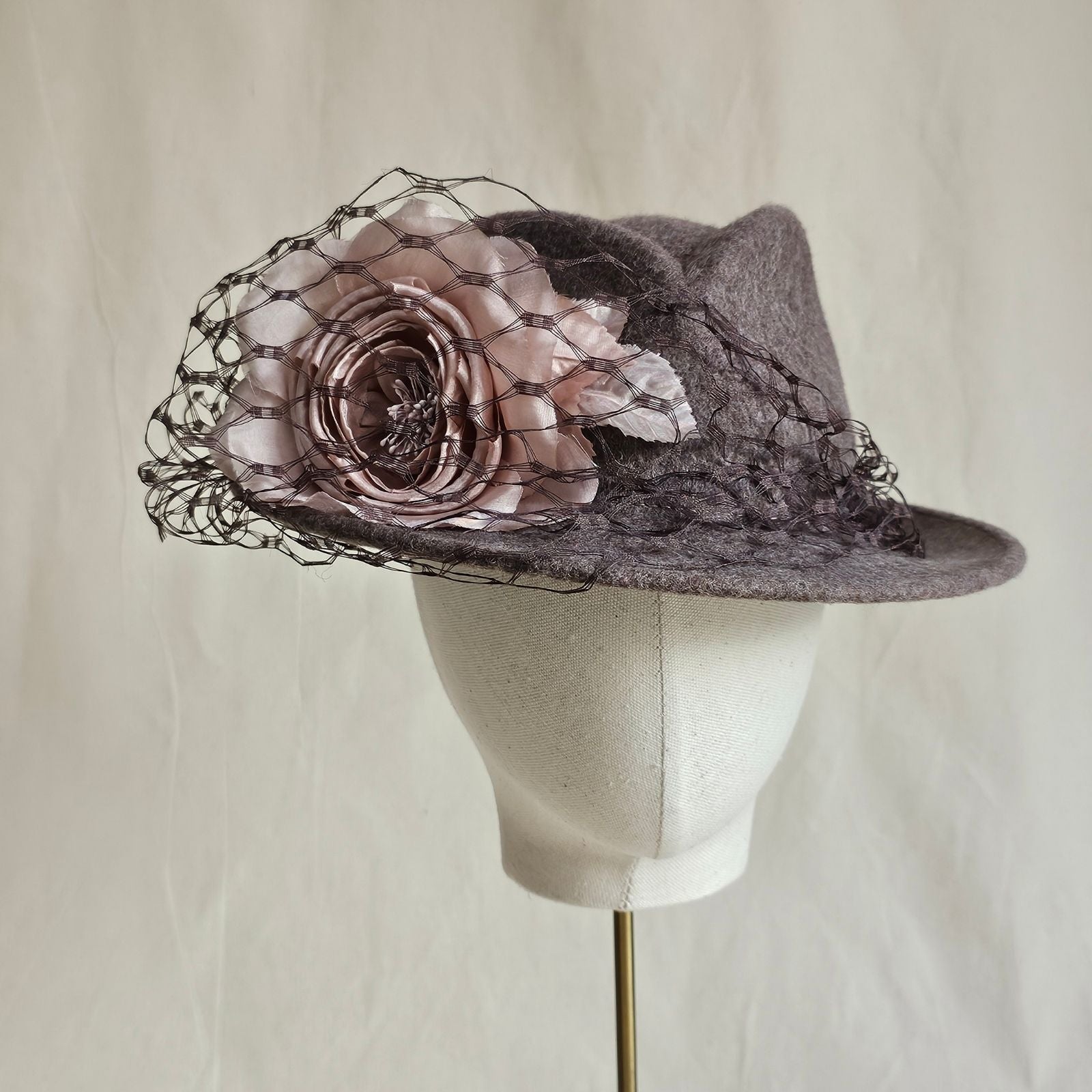 Taupe felt trilby with pink rose and black veil embellishment, front view.
