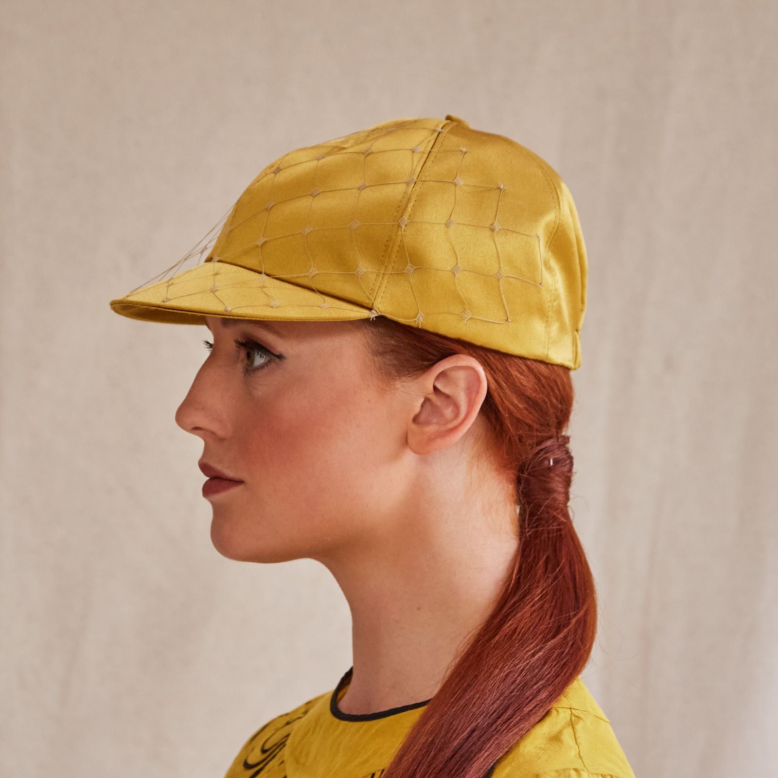 Yellow silk baseball cap with subtle veiling, side view.