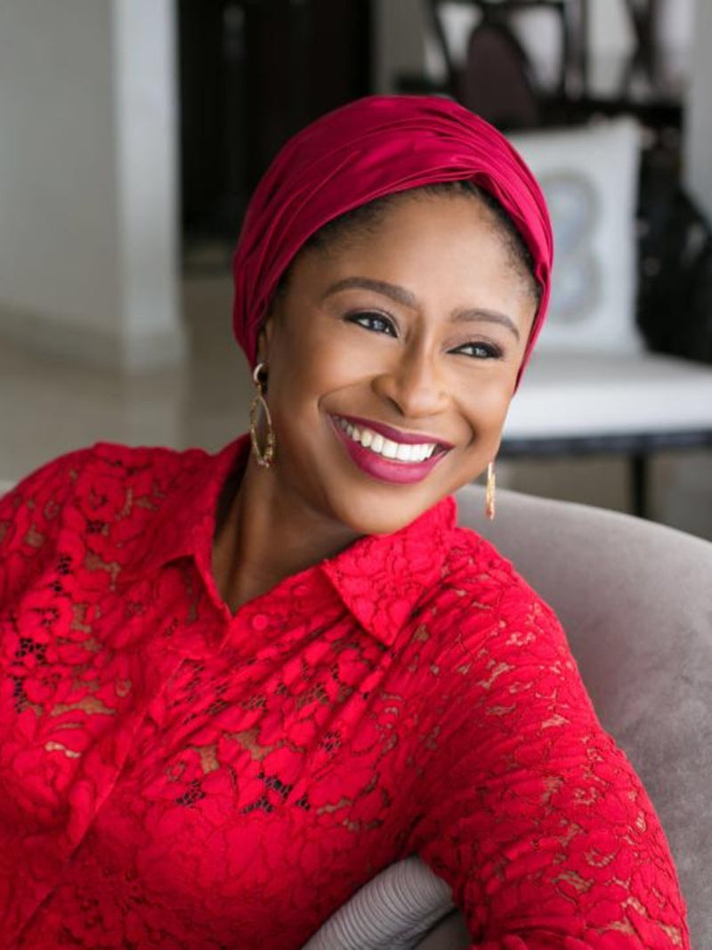 Aisha Rimi wearing a red gathered turban by Nerida Fraiman.