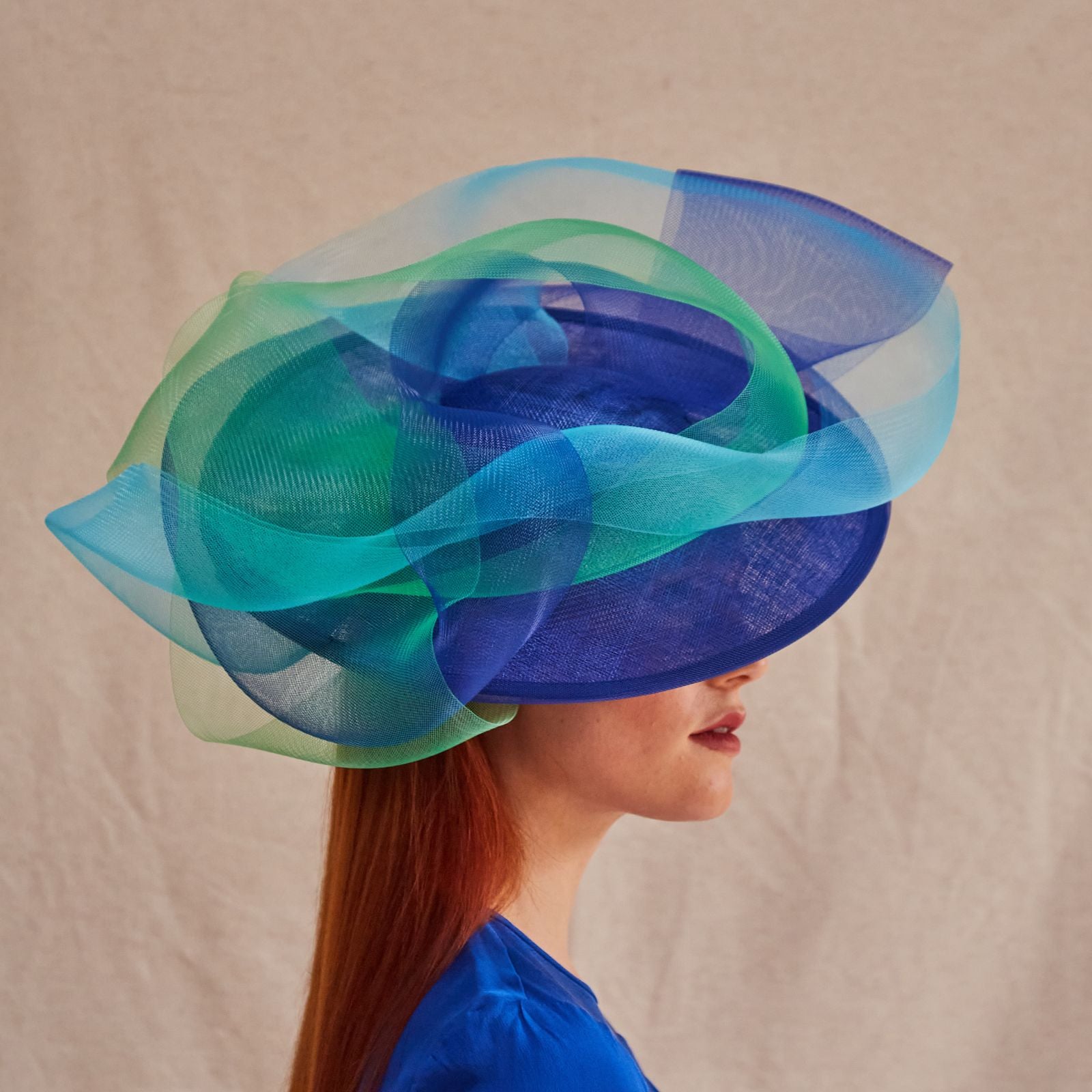 Royal blue, blue and green elegant crin swirl ascot hat, side view.
