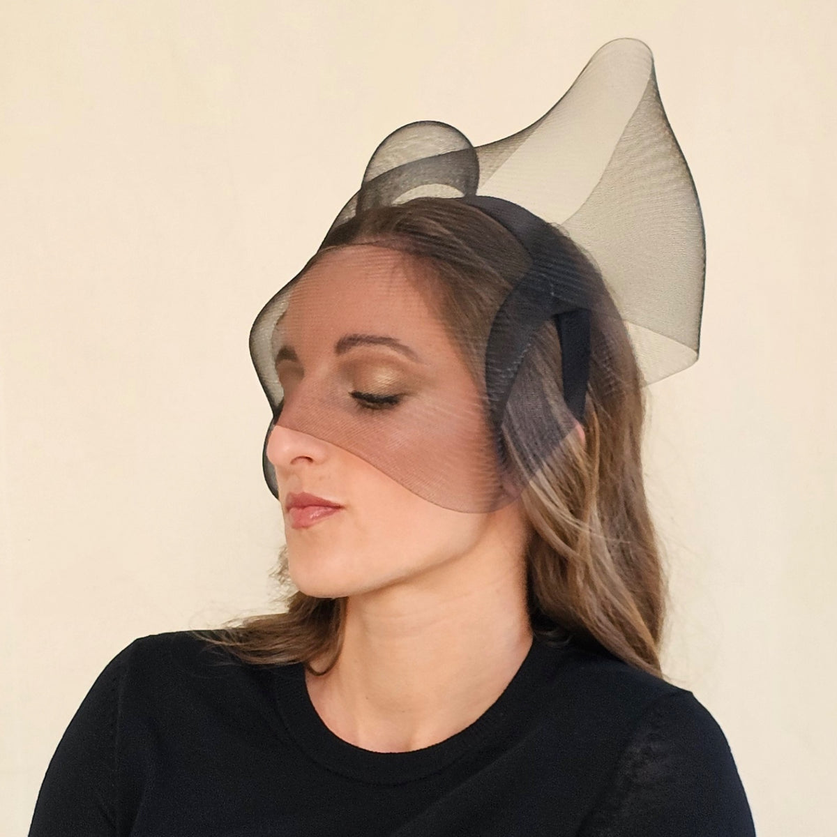 Angled close-up of black double-twist crin bow headband with face
veil.