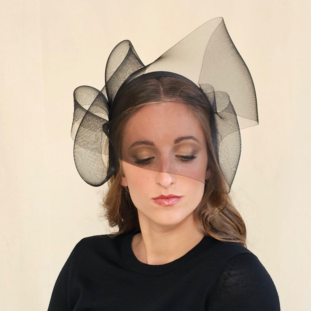 Front view of black crin bow headband showing sheer folds across
the face.