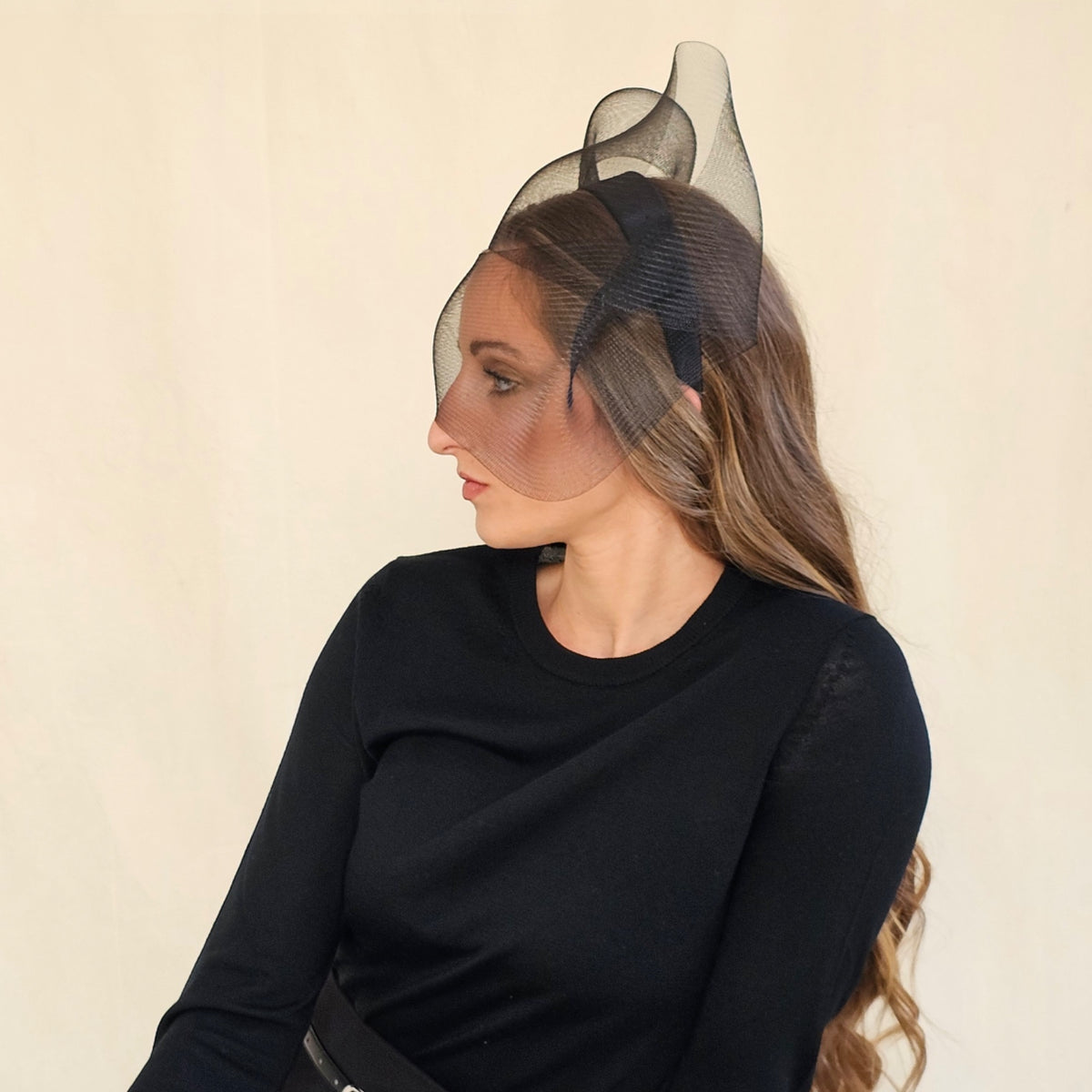Side view of black double-twist crin bow headband on a seated
model.
