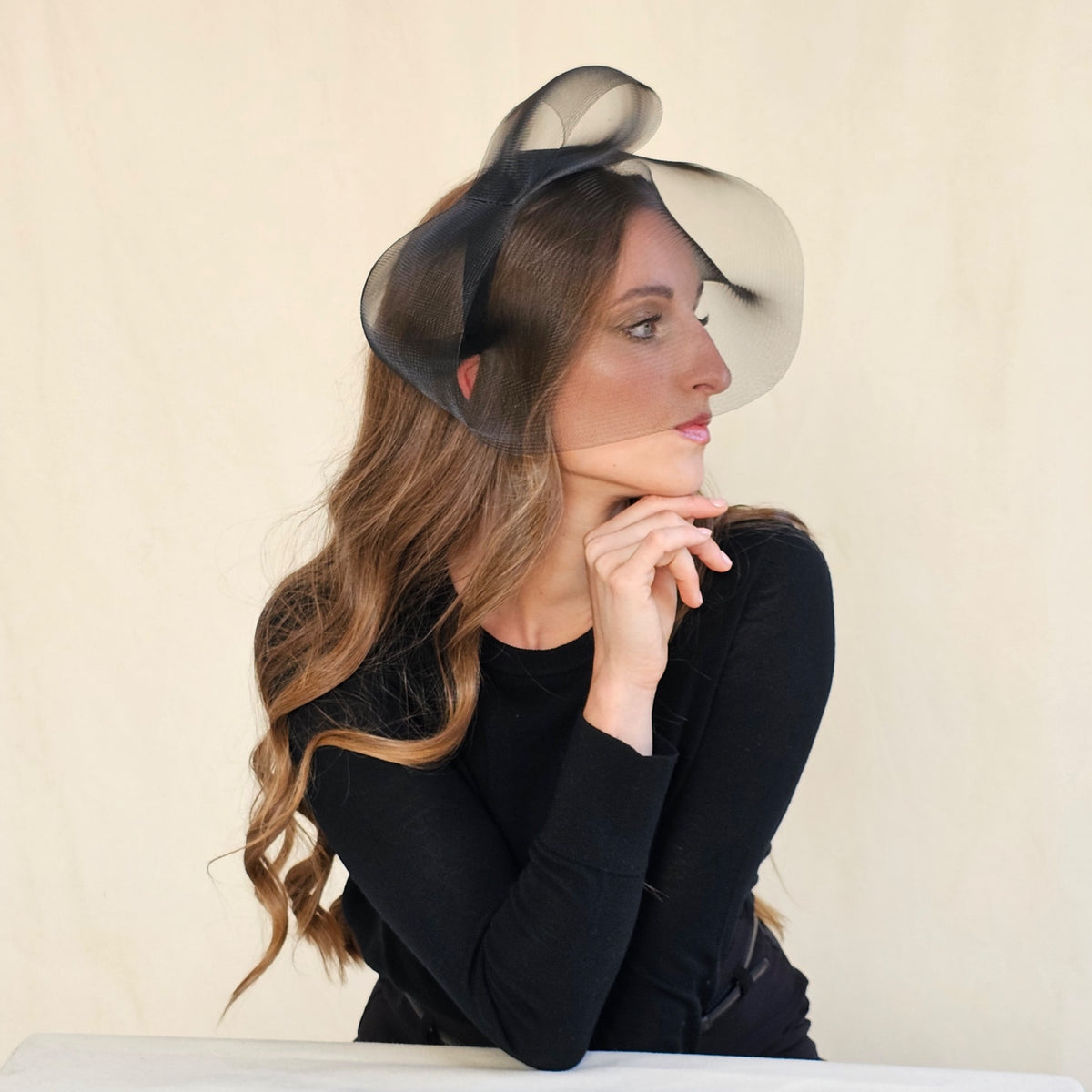 Black crin veil headband in profile on a seated model.