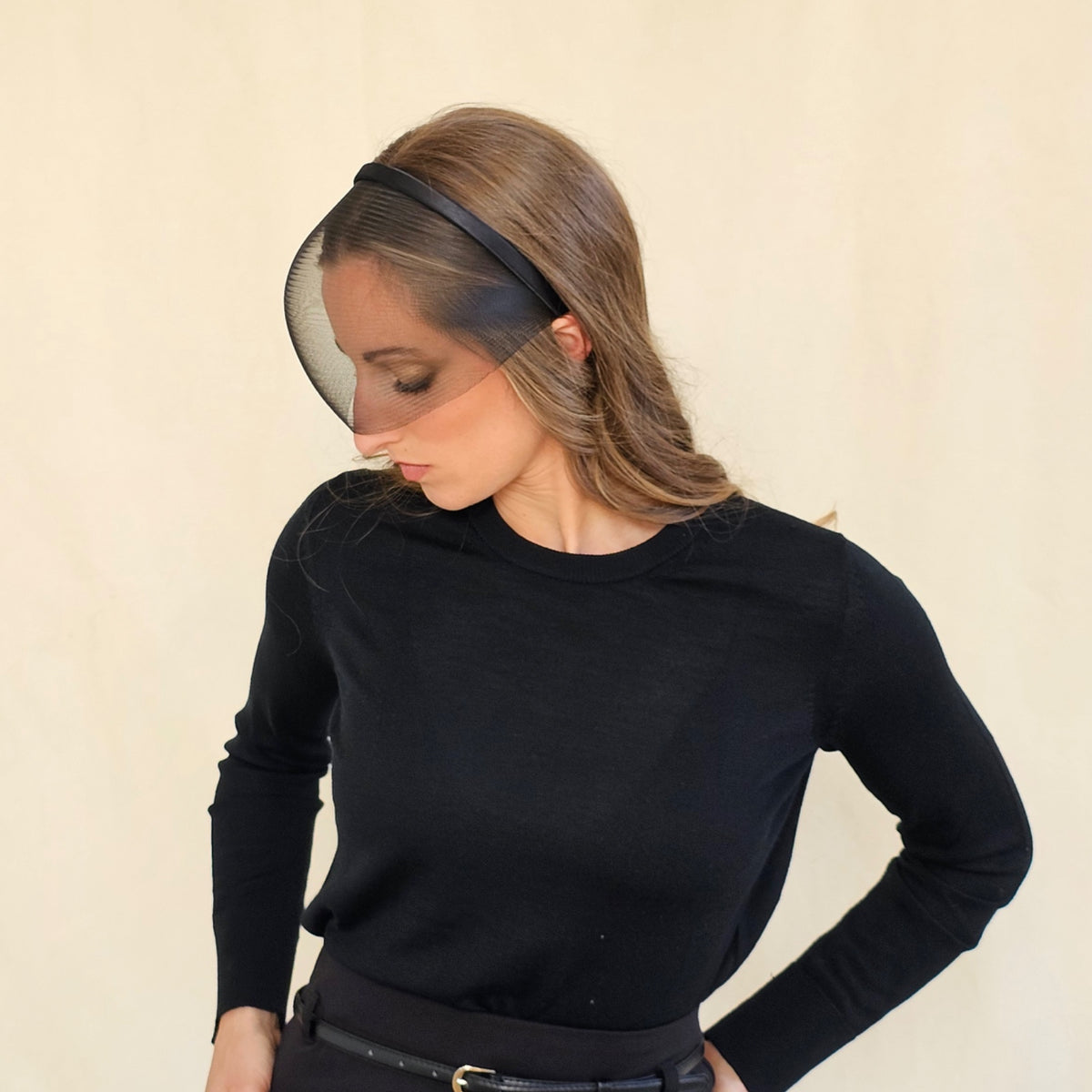 Side view of black crin face-cage headband on a standing model.