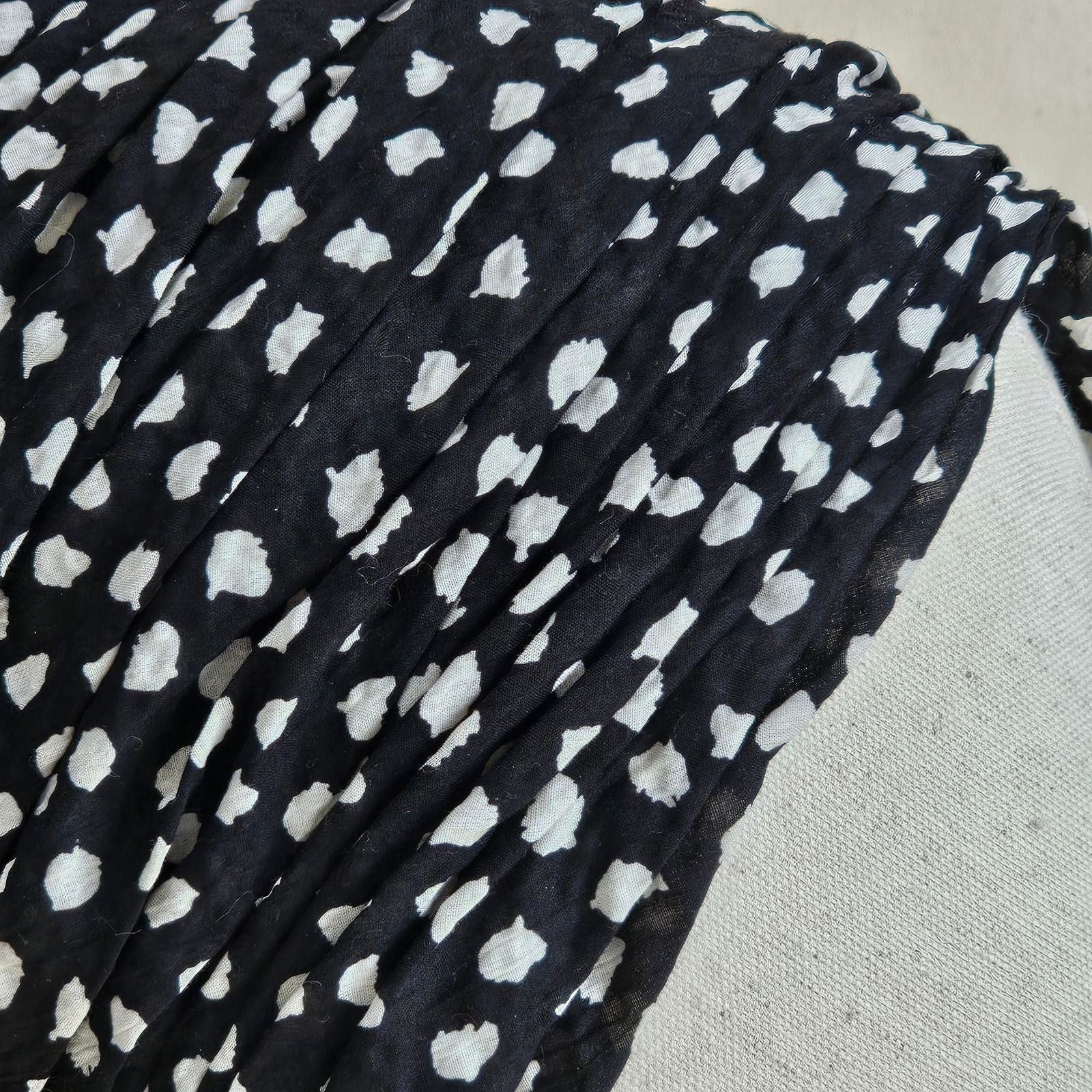 Detail of black gathered cotton turban with ivory dot print.