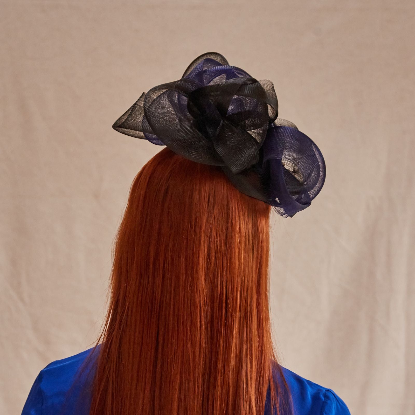 Black and navy peak fascinator with beautiful crin swirls and dragonfly embellishment, rear view.