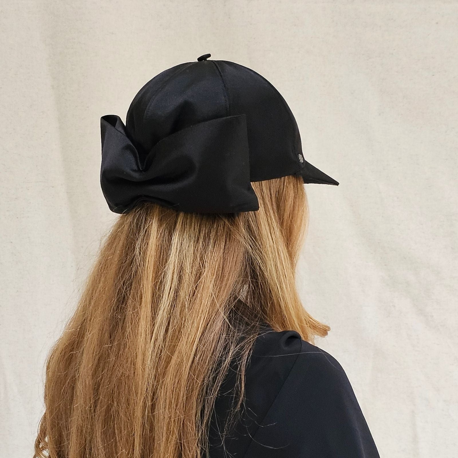 Black silk baseball cap with dramatic bow, right back view.