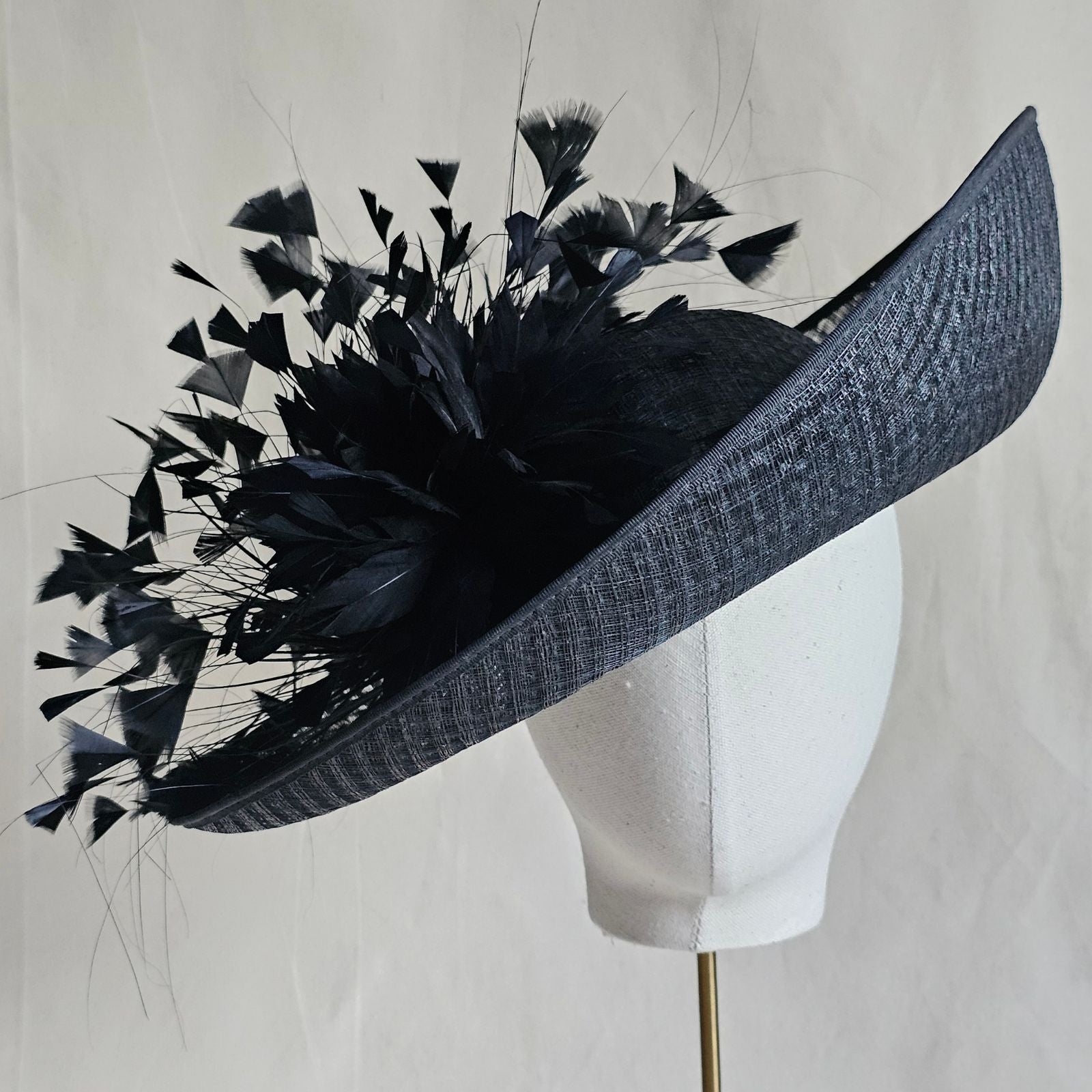 Black siname breton hat with beautiful feather flower, front view.