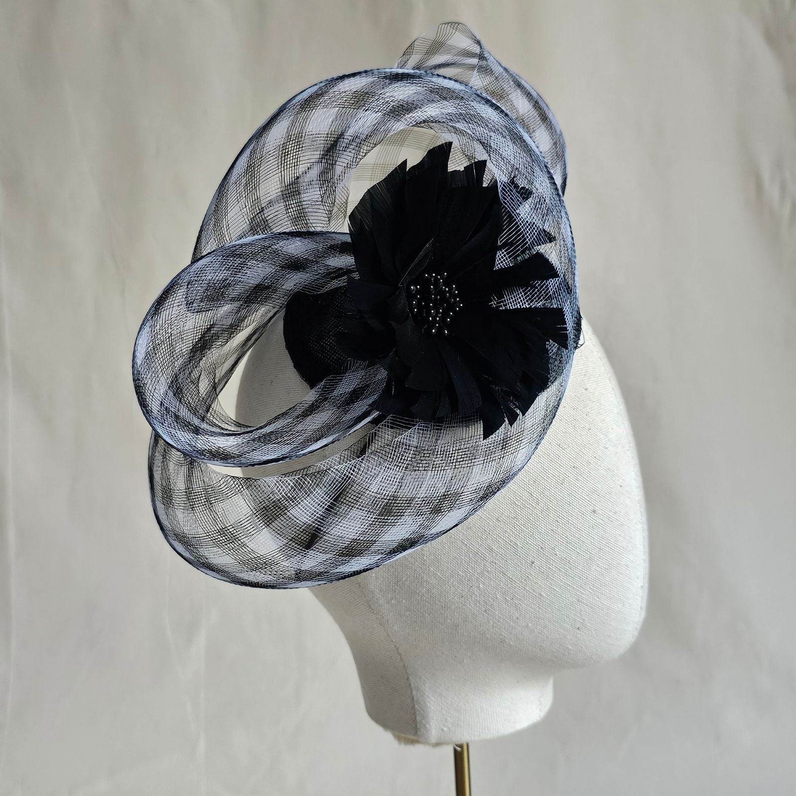 Fascinator with black and white check crin swirl and beautiful black flower, right view.