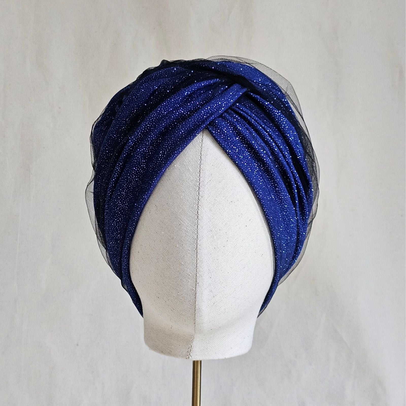 Blue sparkle turban with tulle, beautifully braided, front view.