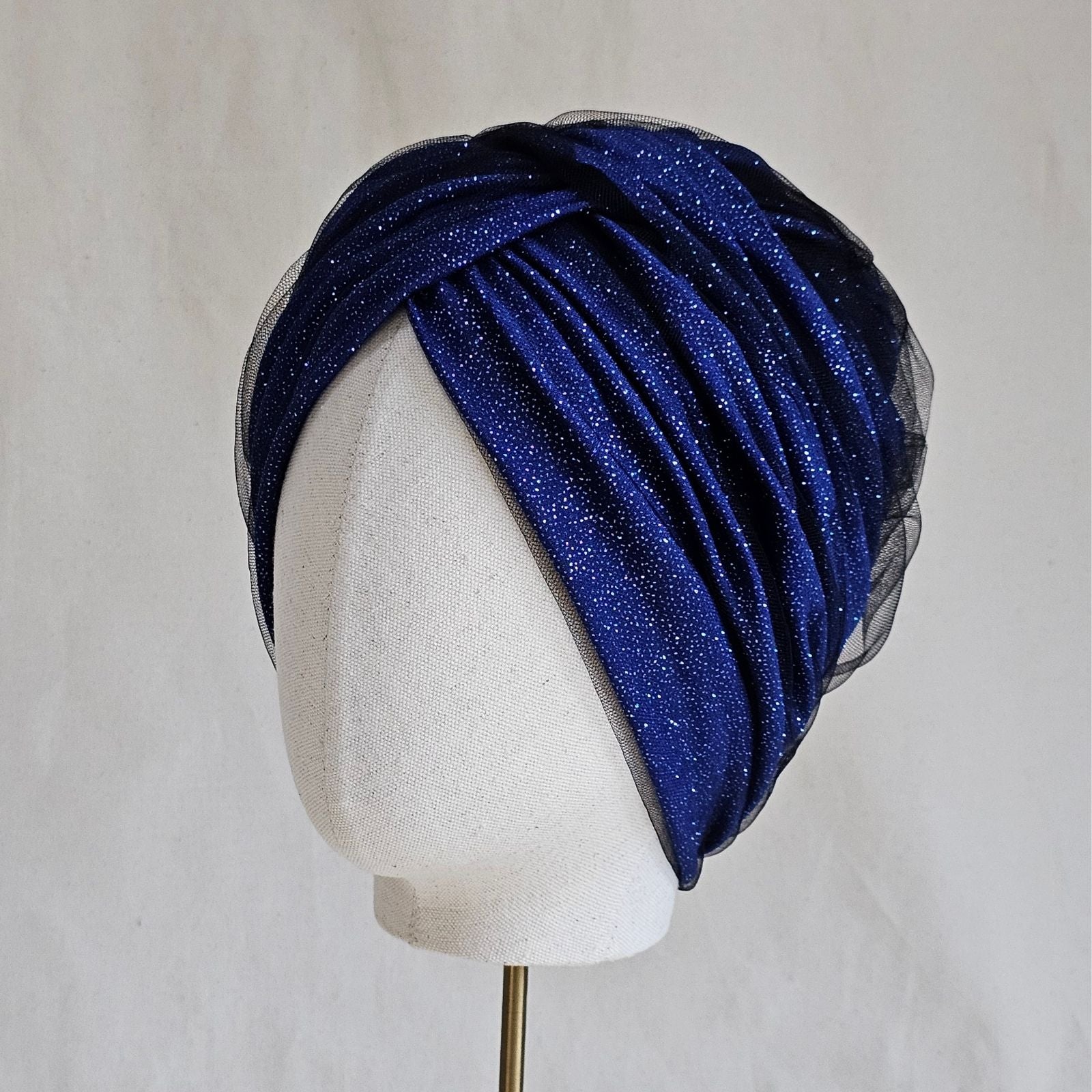 Blue sparkle tulle turban, intricately braided, left view.