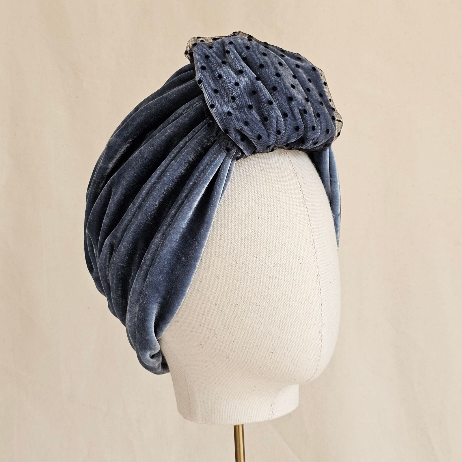 Blue velvet gathered turban with dot tulle detailed front loop, angle view.