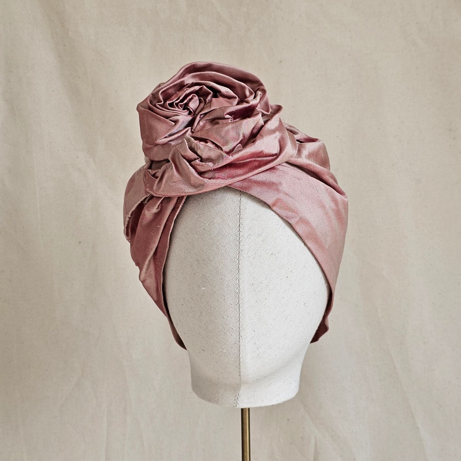 Blush silk turban with beautifully sculpted intricate rose knot, front view.
