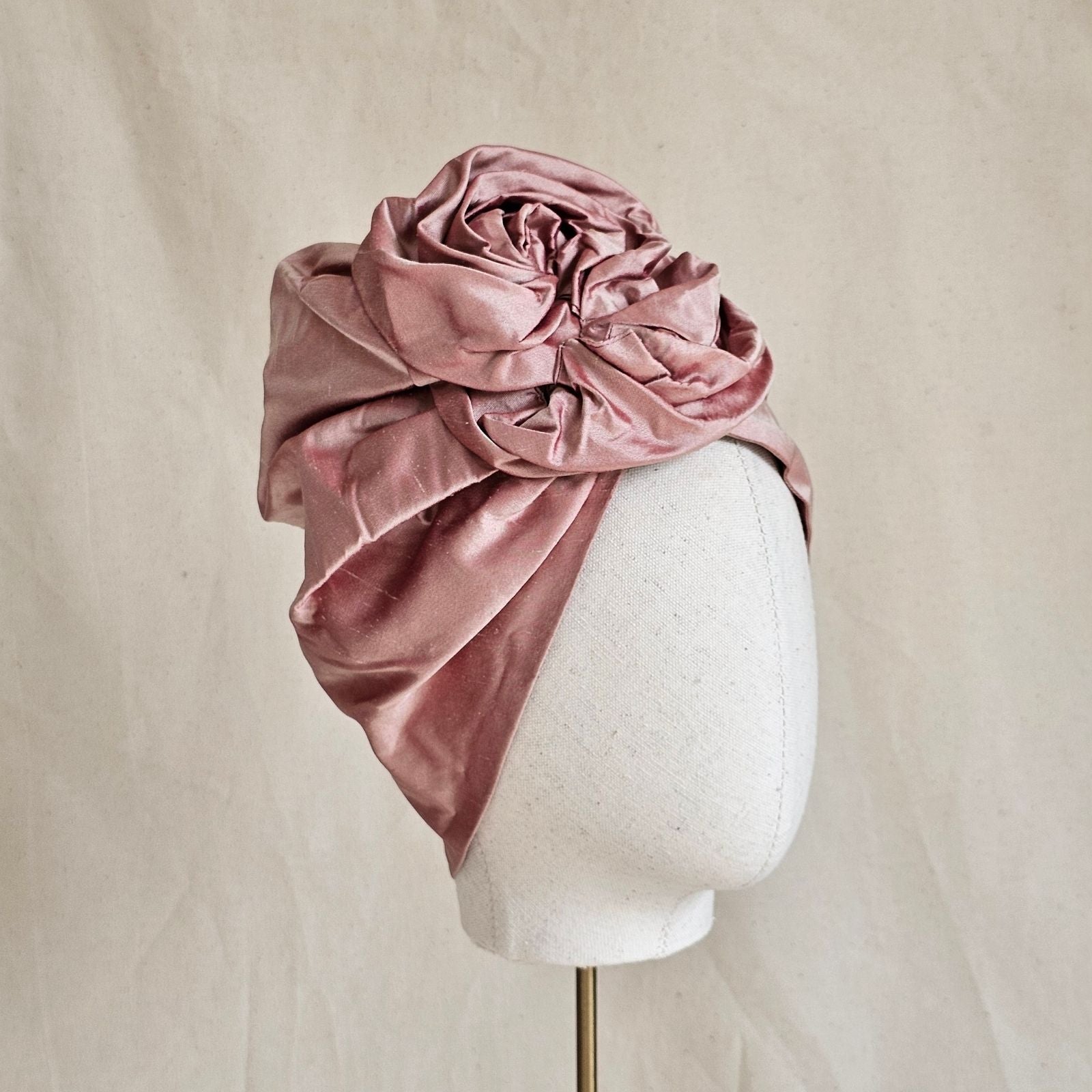 Blush silk turban with beautifully sculpted intricate rose knot, side view.