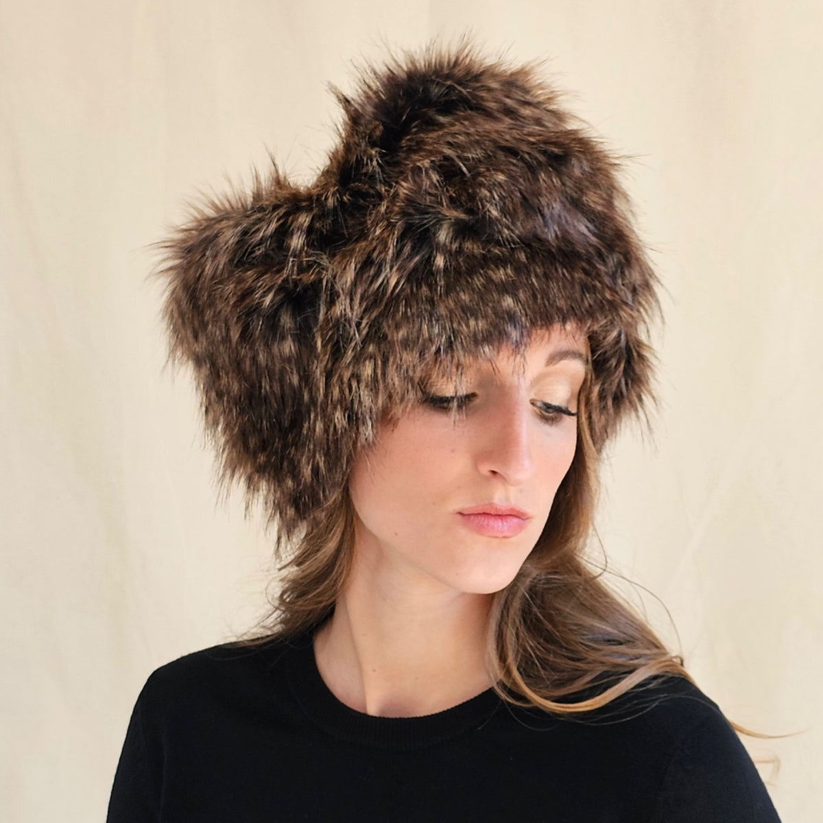 lose-up of raccoon print faux fur pillbox showing gathered texture.