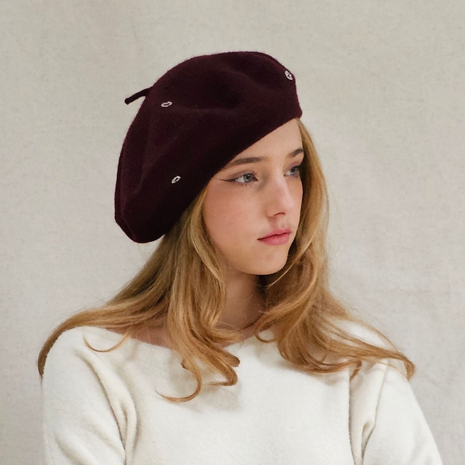 Burgundy wool beret with beautiful silver heart embellishments, side view.