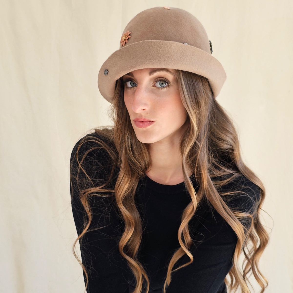 Angled close-up of camel felt cloche showing flower and
monogram embellishments.