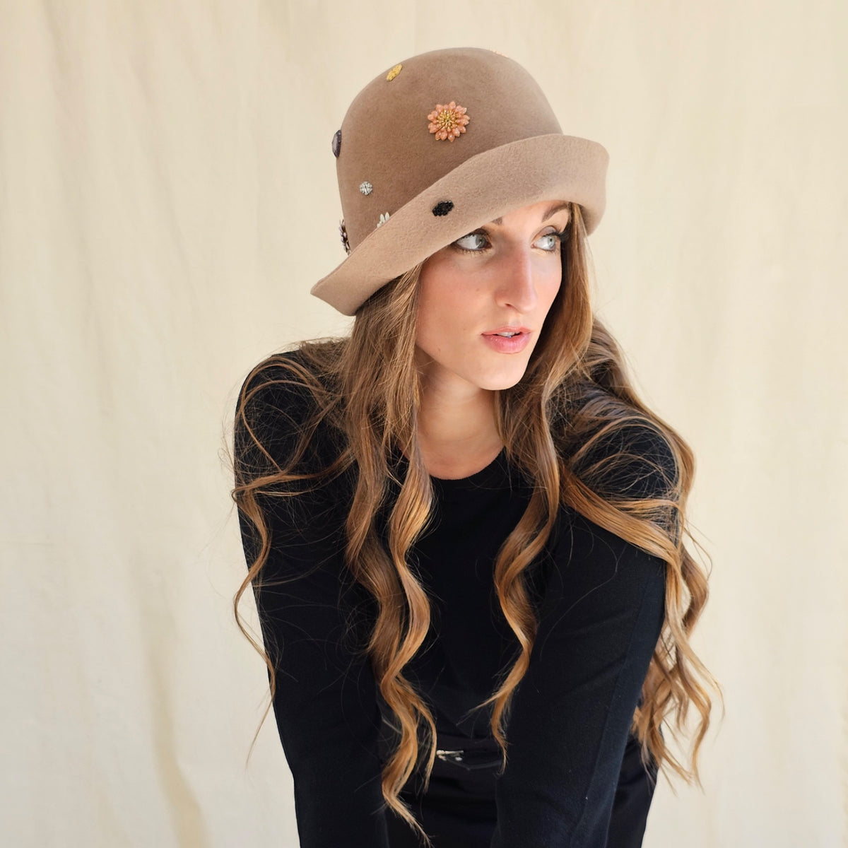 Side view of camel felt cloche showing flower and monogram
details.