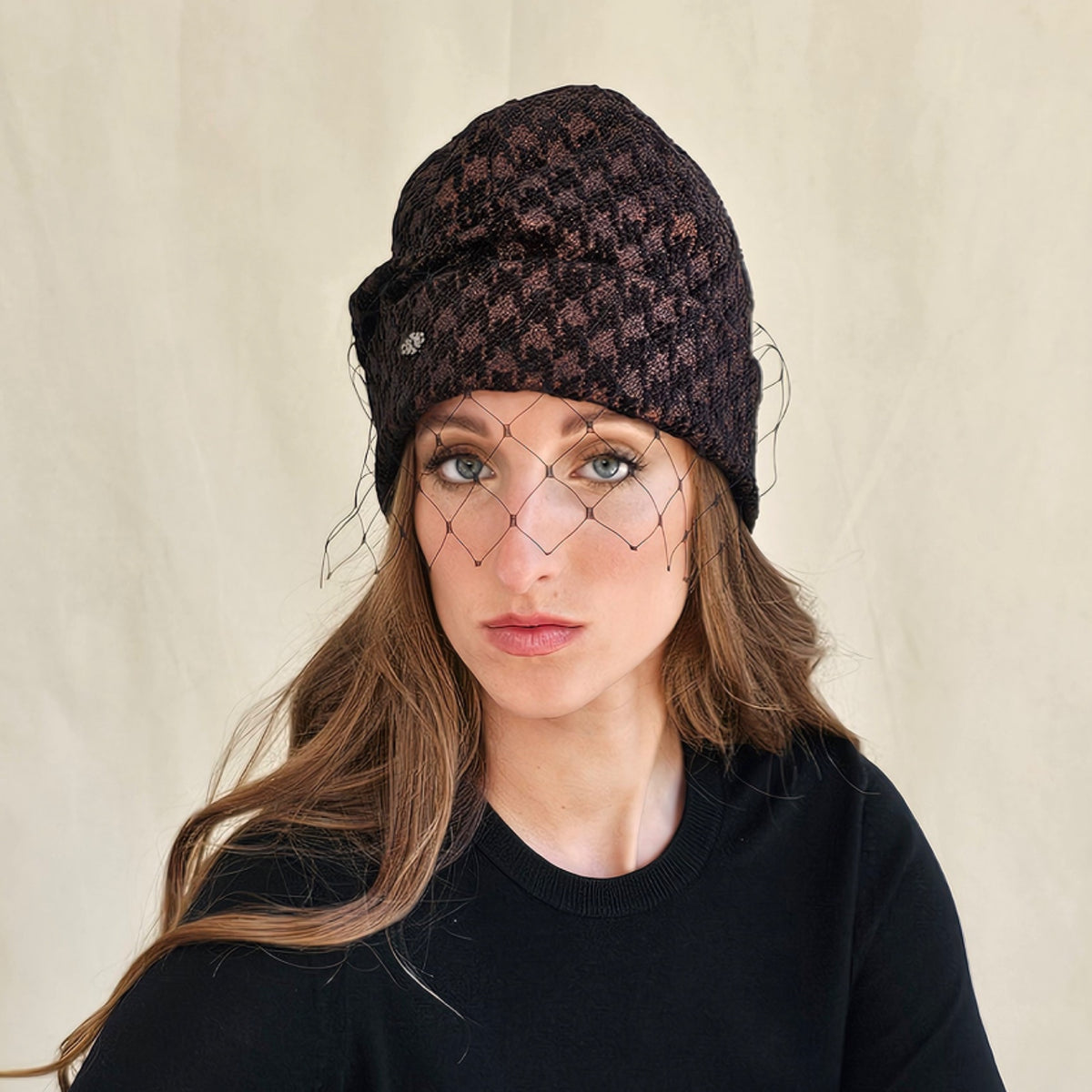 Brown metallic houndstooth beanie with black face veil, worn on a
model.