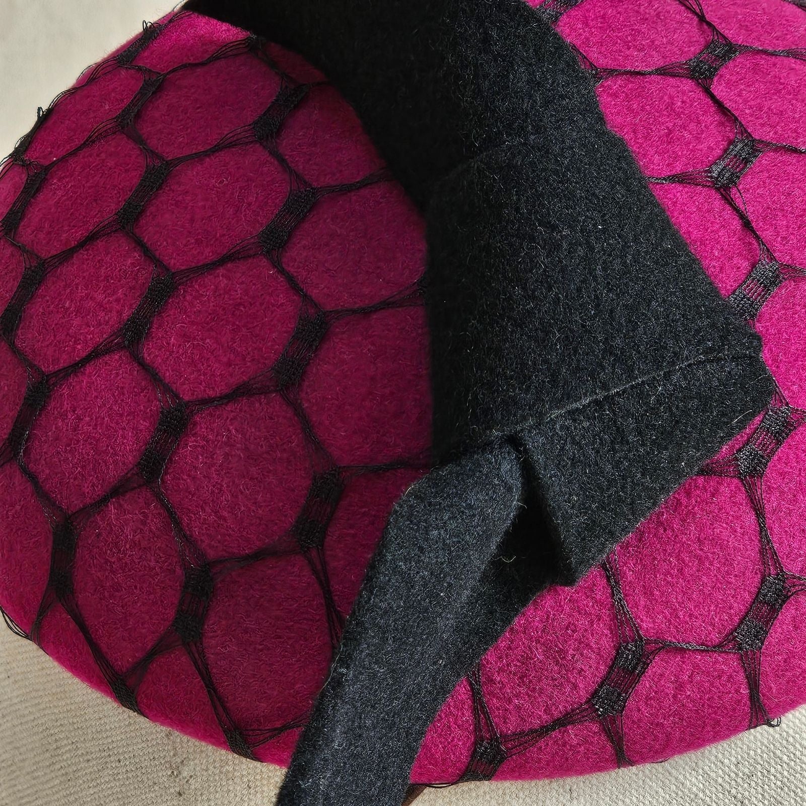 Detail of fuchsia felt beret with black bow and veiling.