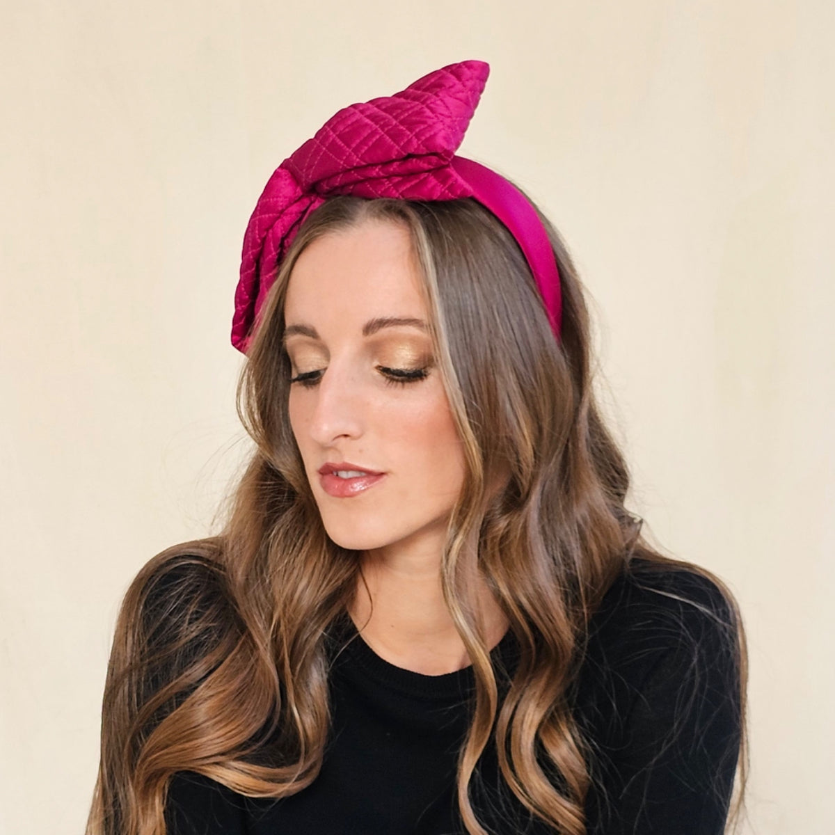 Close-up of fuchsia silk bow headband showing diamond quilting.