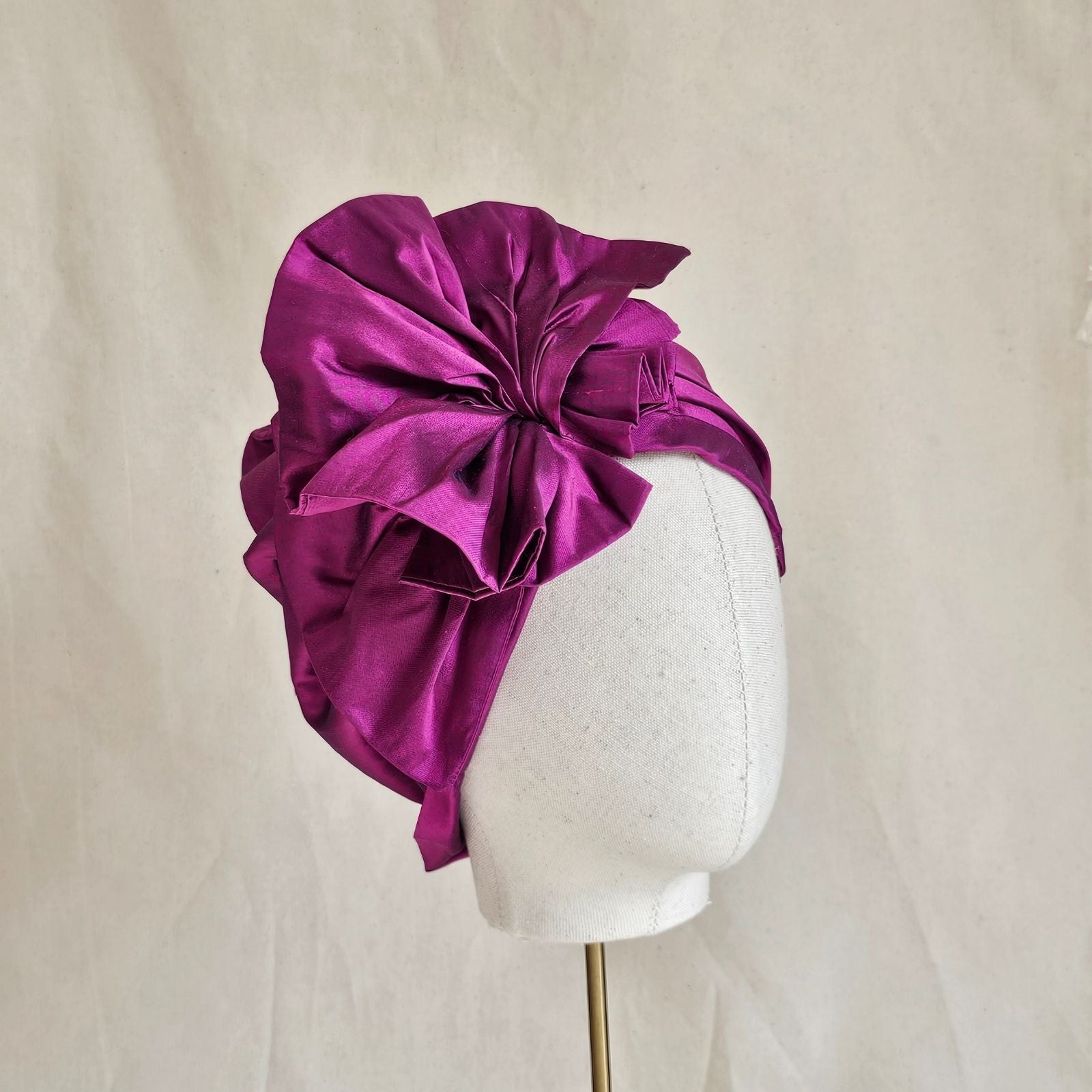 Fuchsia silk turban with intricate ruffle, angle view.