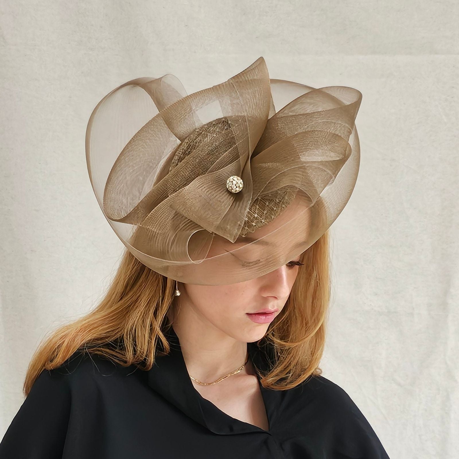 Gold disc hat with elegant gold crin swirl and crystal diamanté globe, side view.