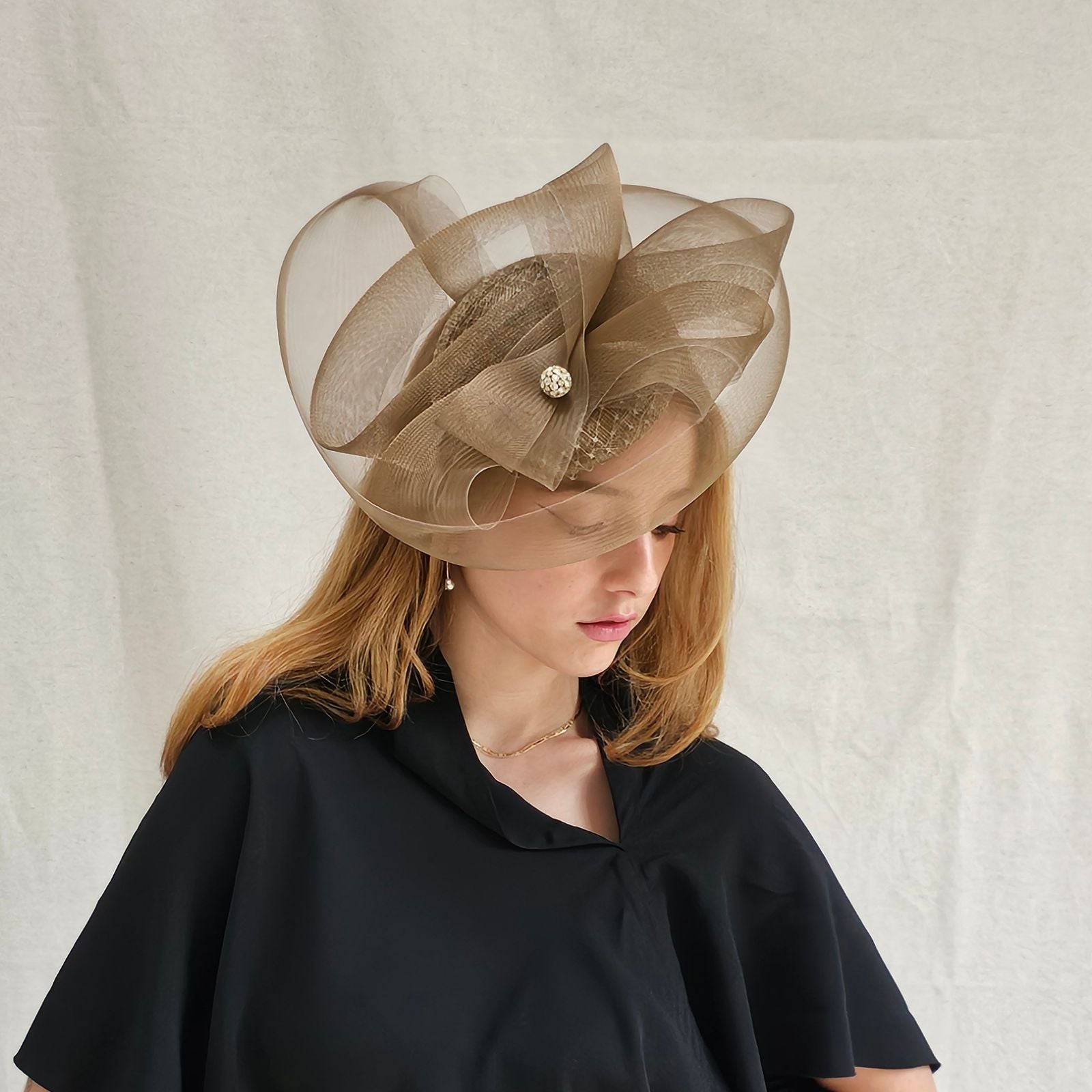 Gold fascinator with elegant crin swirls and crystal diamanté globe embellishment, side view.
