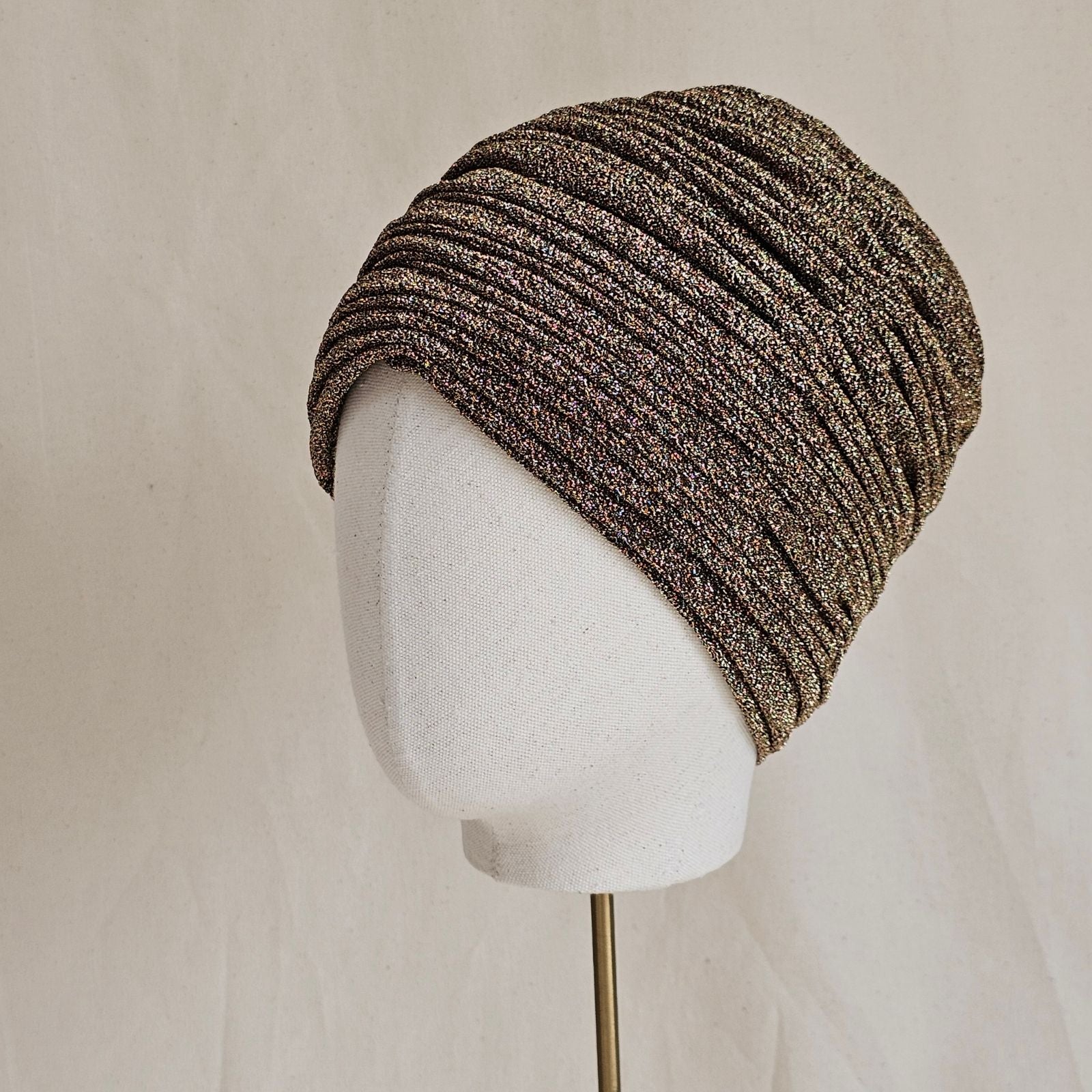 Gold lurex turban with beautiful gathers, angle view.