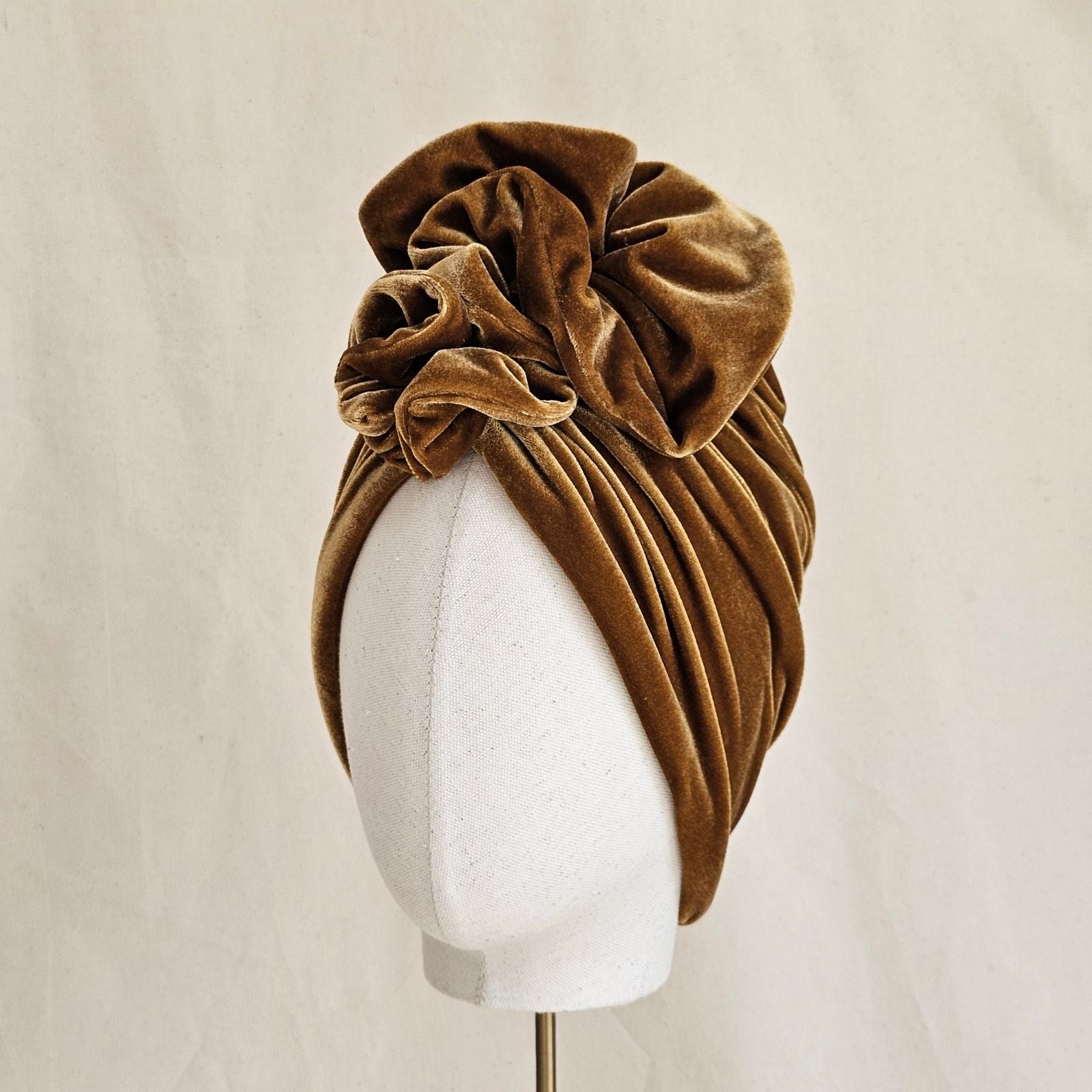Gold velvet turban gathered into elegant ruffle, left view.