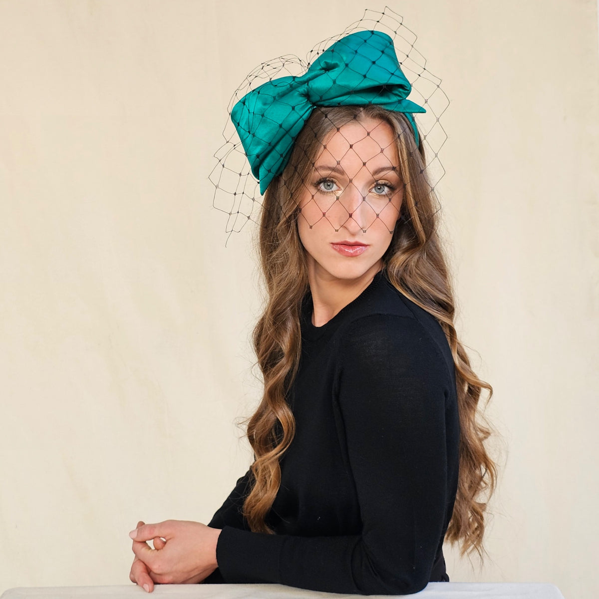 Front view of emerald silk bow headband with black net veil.