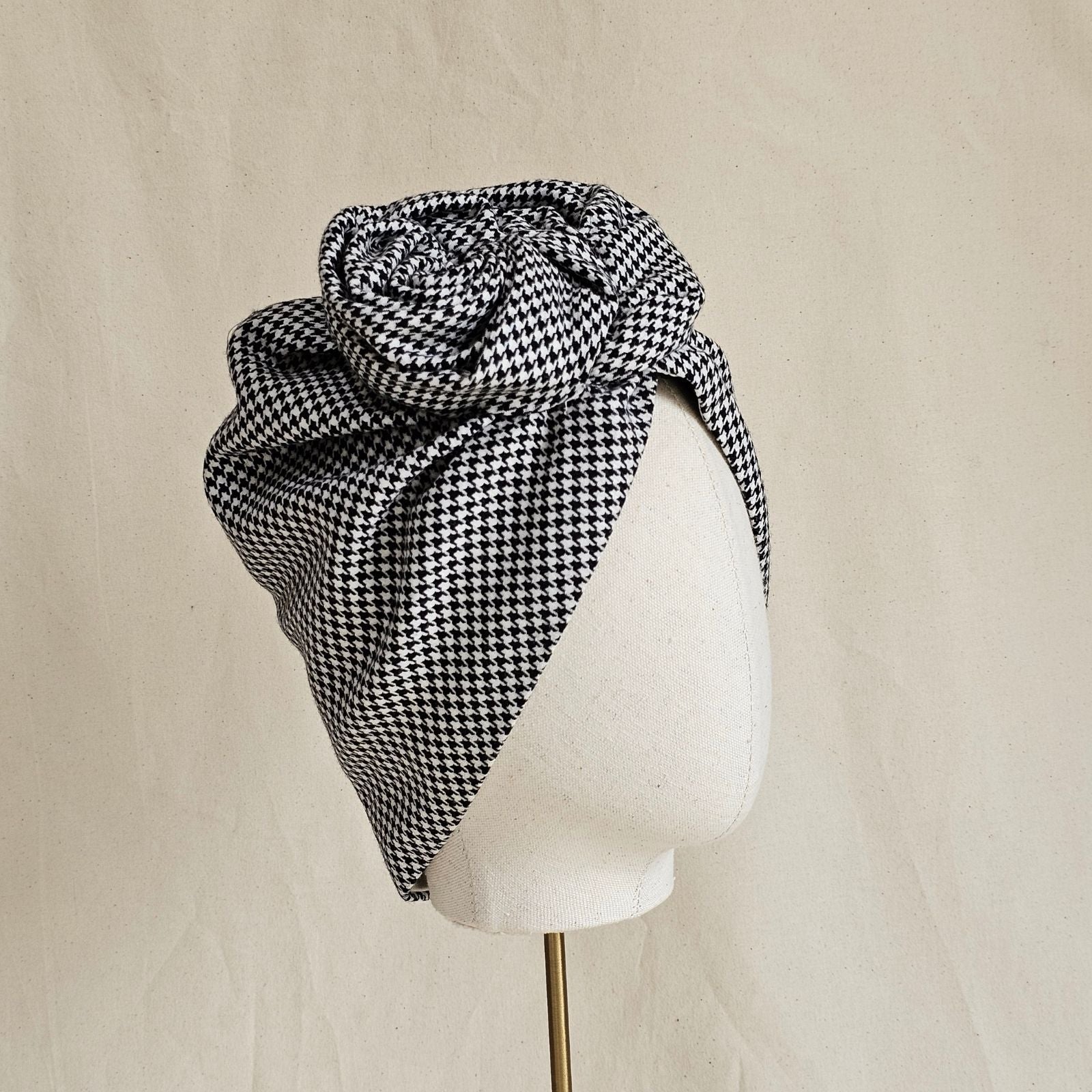 Houndstooth turban with softly sculpted rose knot, angle view.