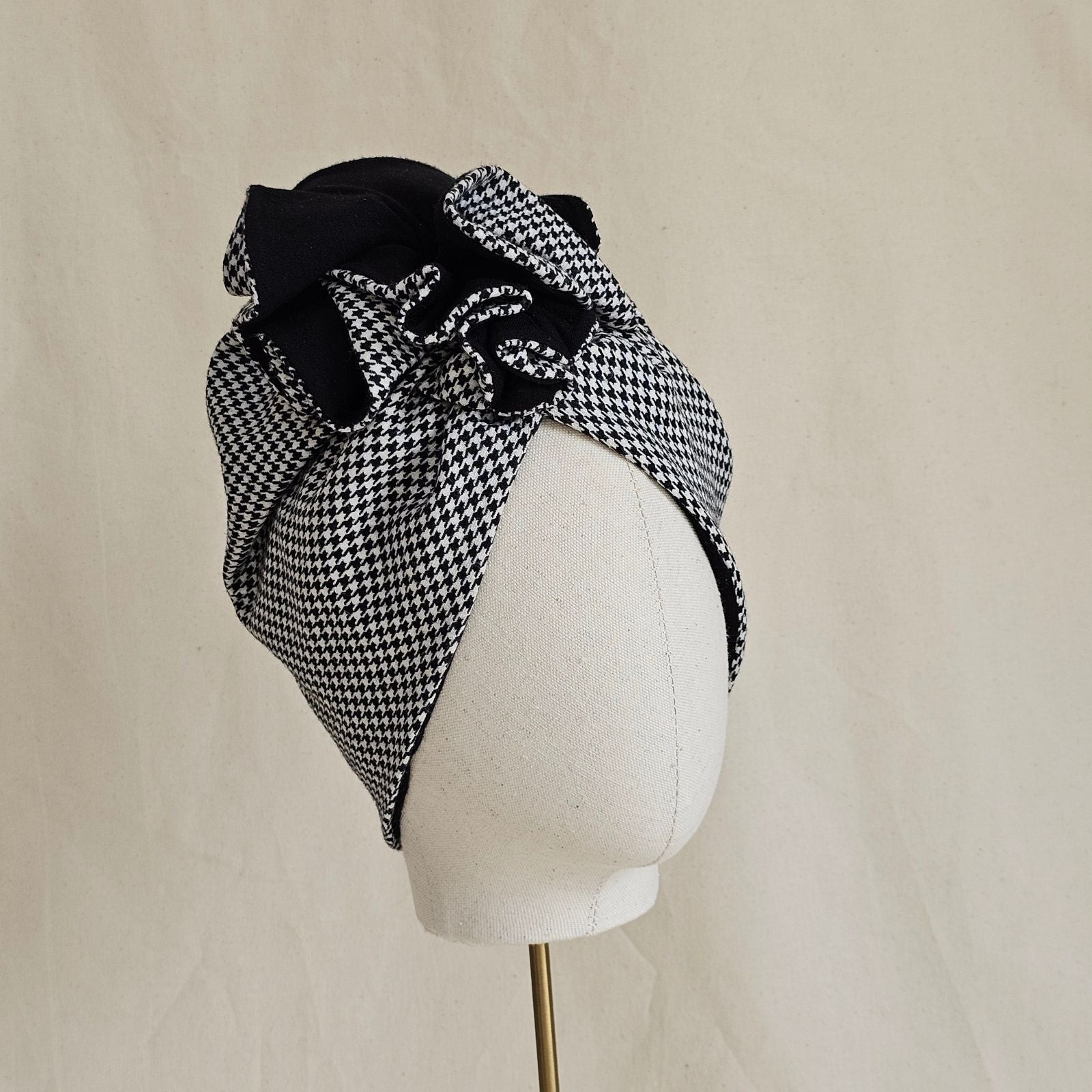 Houndstooth turban with elegant black ruffle, angle view.