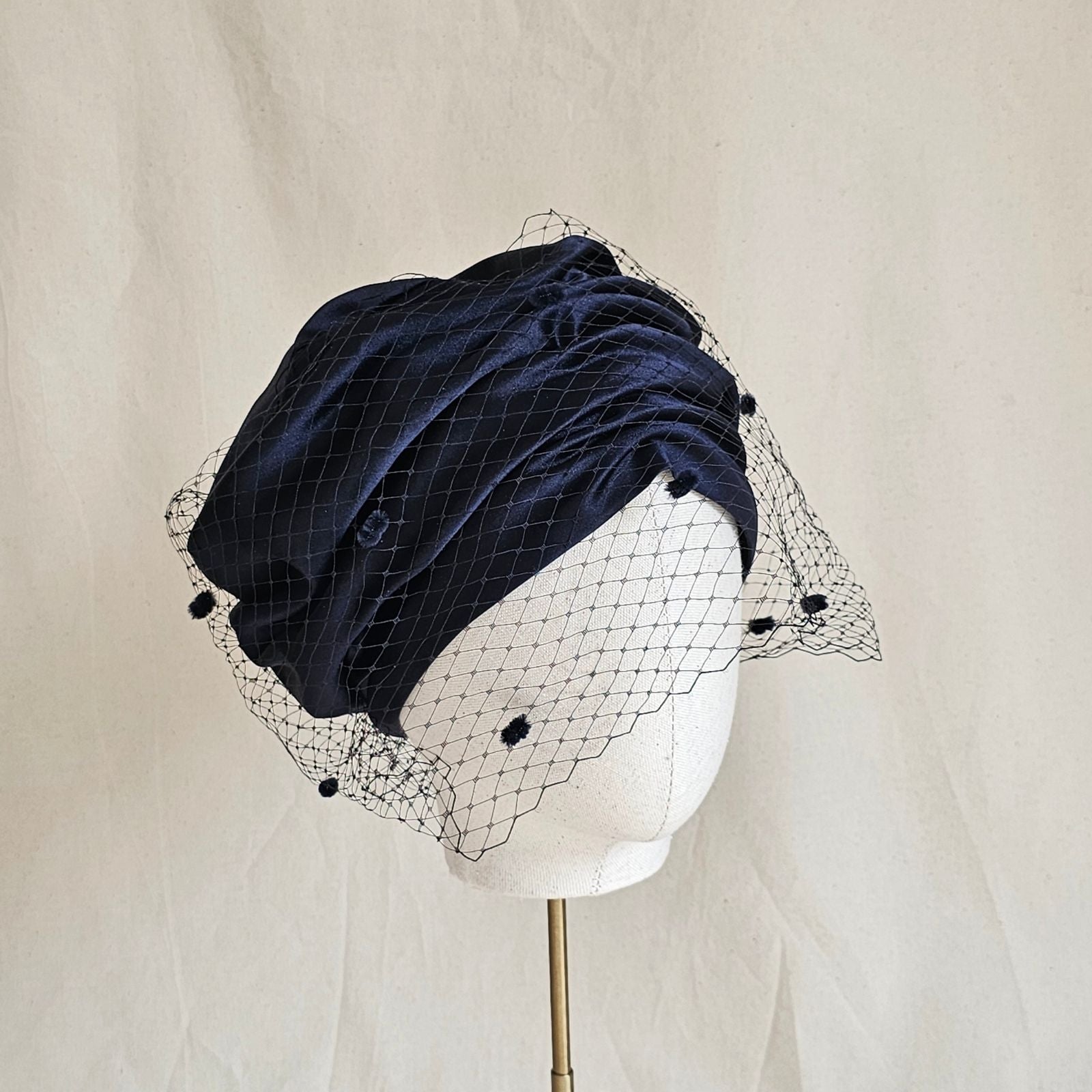 Ink silk and satin beret turban with dotted veil, angle view.