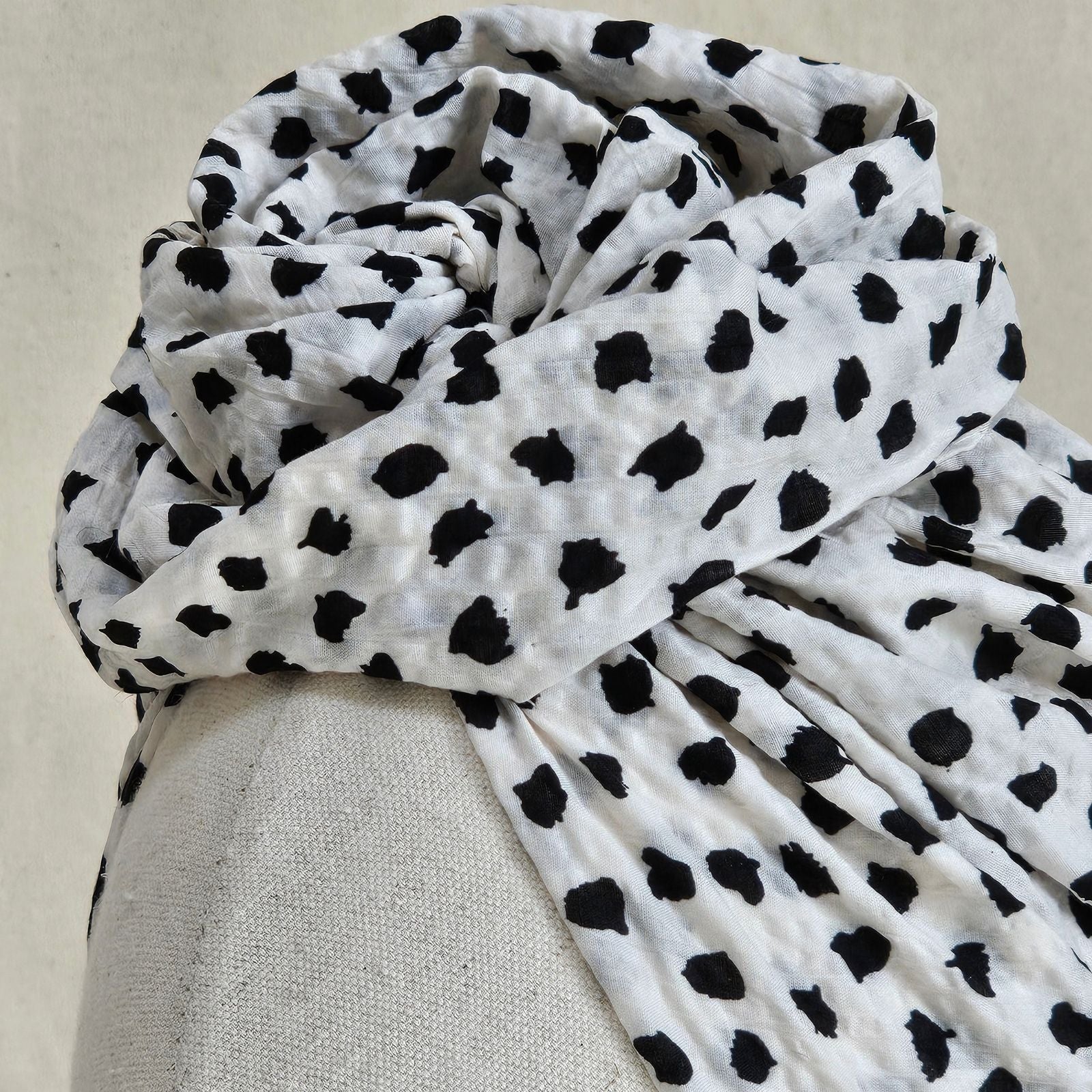 Detail of ivory cotton turban with black dot print and sculpted rose knot.