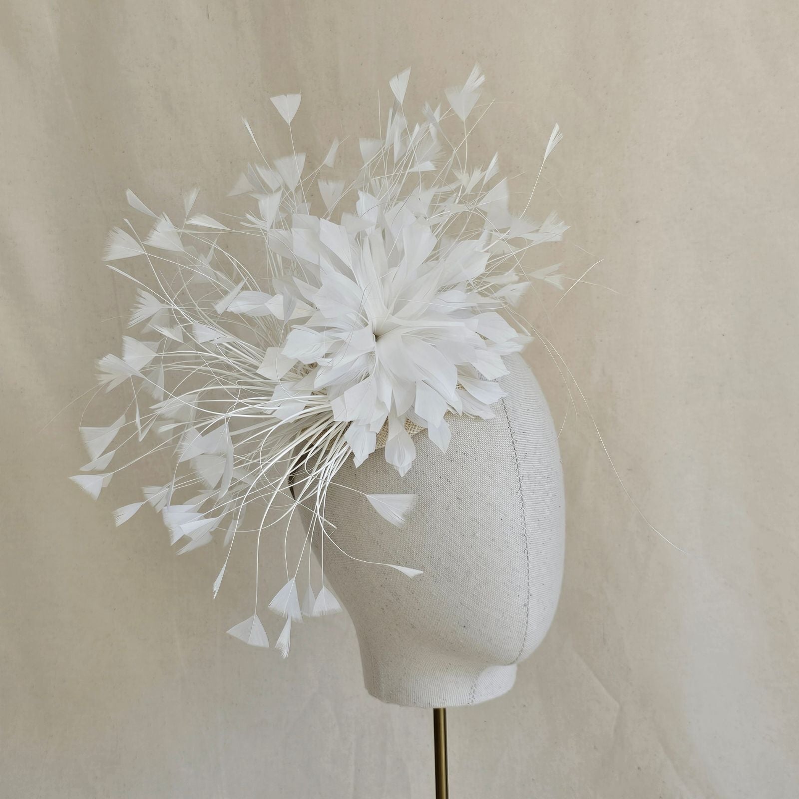 Ivory feather fascinator with feather flower, side view.