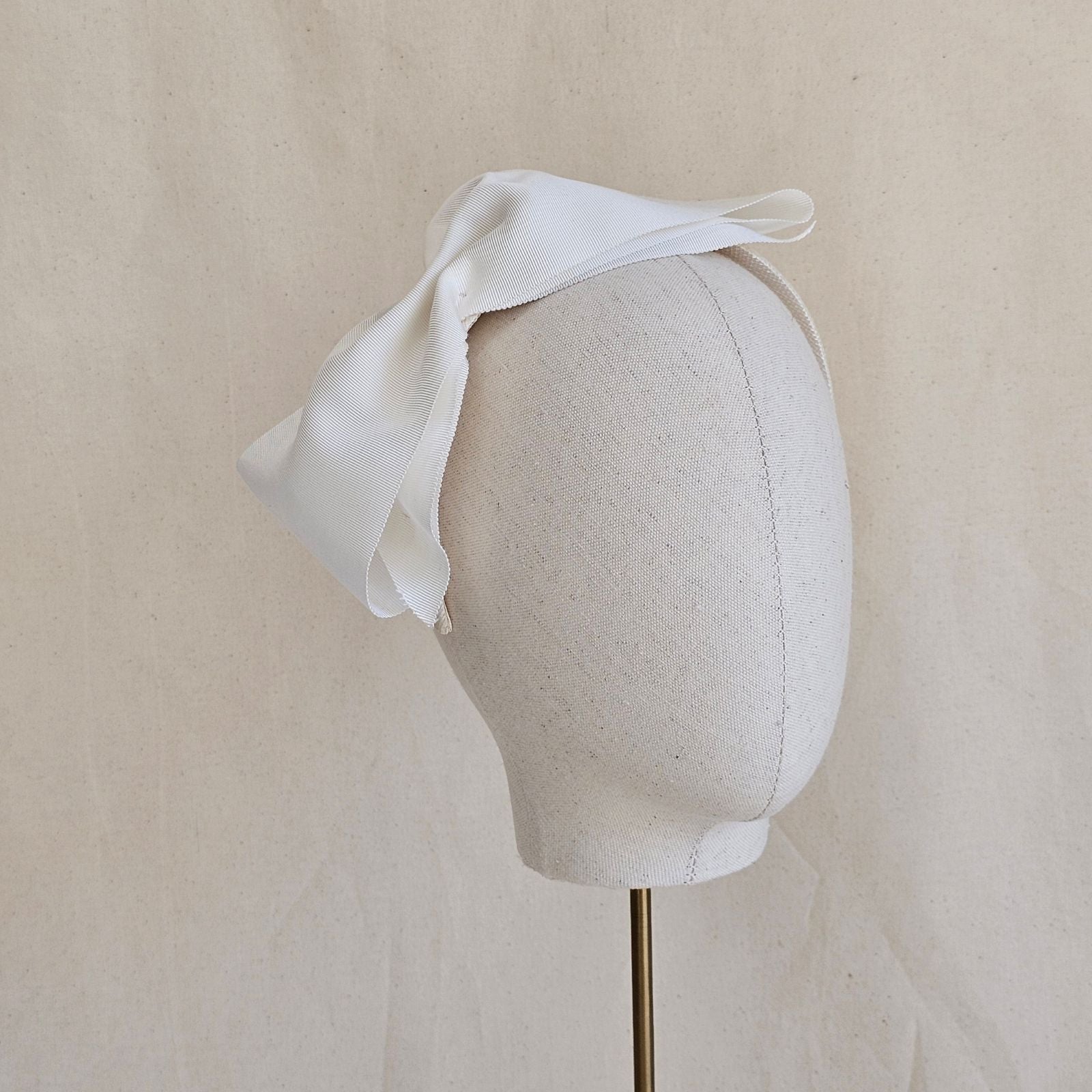 Ivory wide petersham bow on a headband.