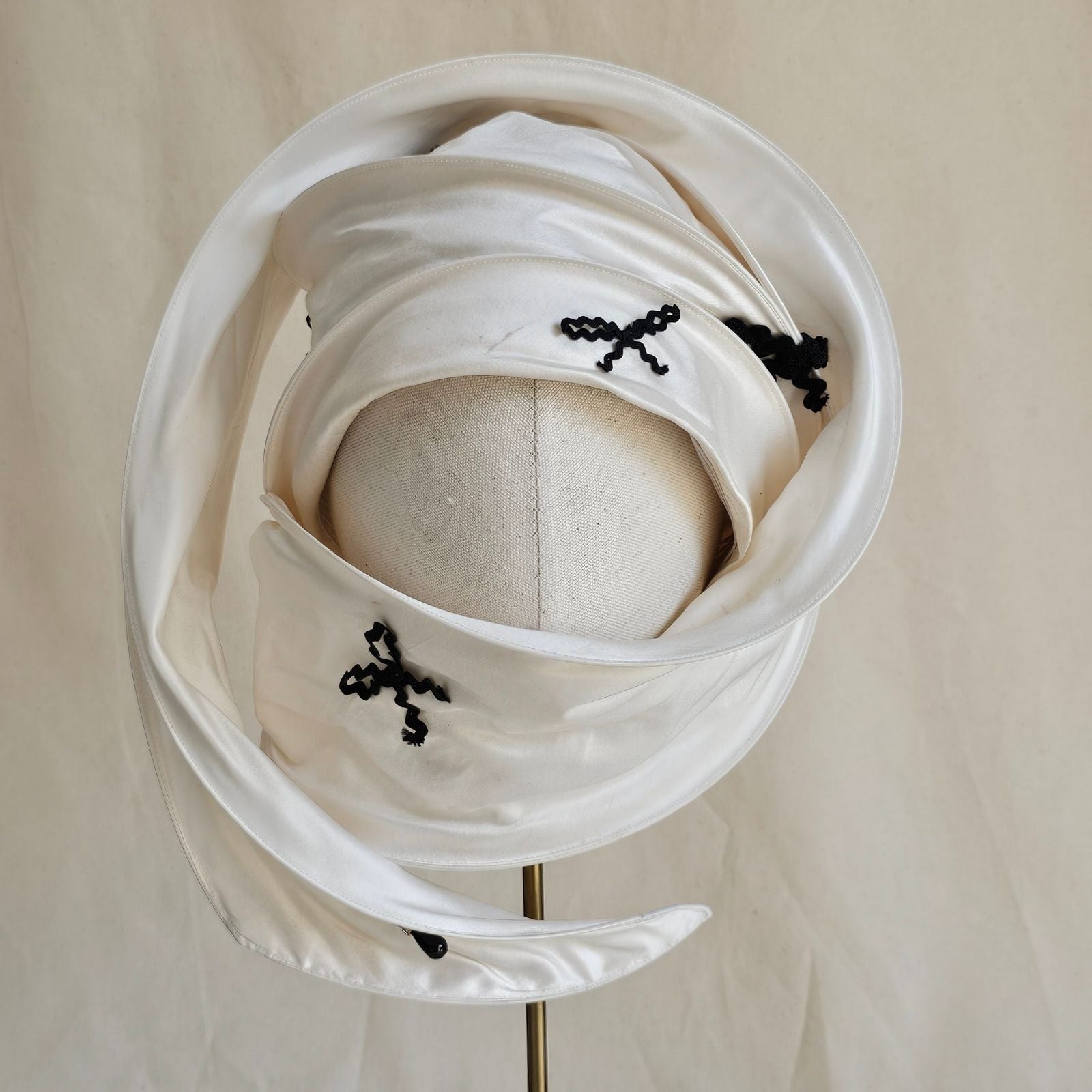 Ivory silk scarf turban with black bow detailing, wrapped front view.