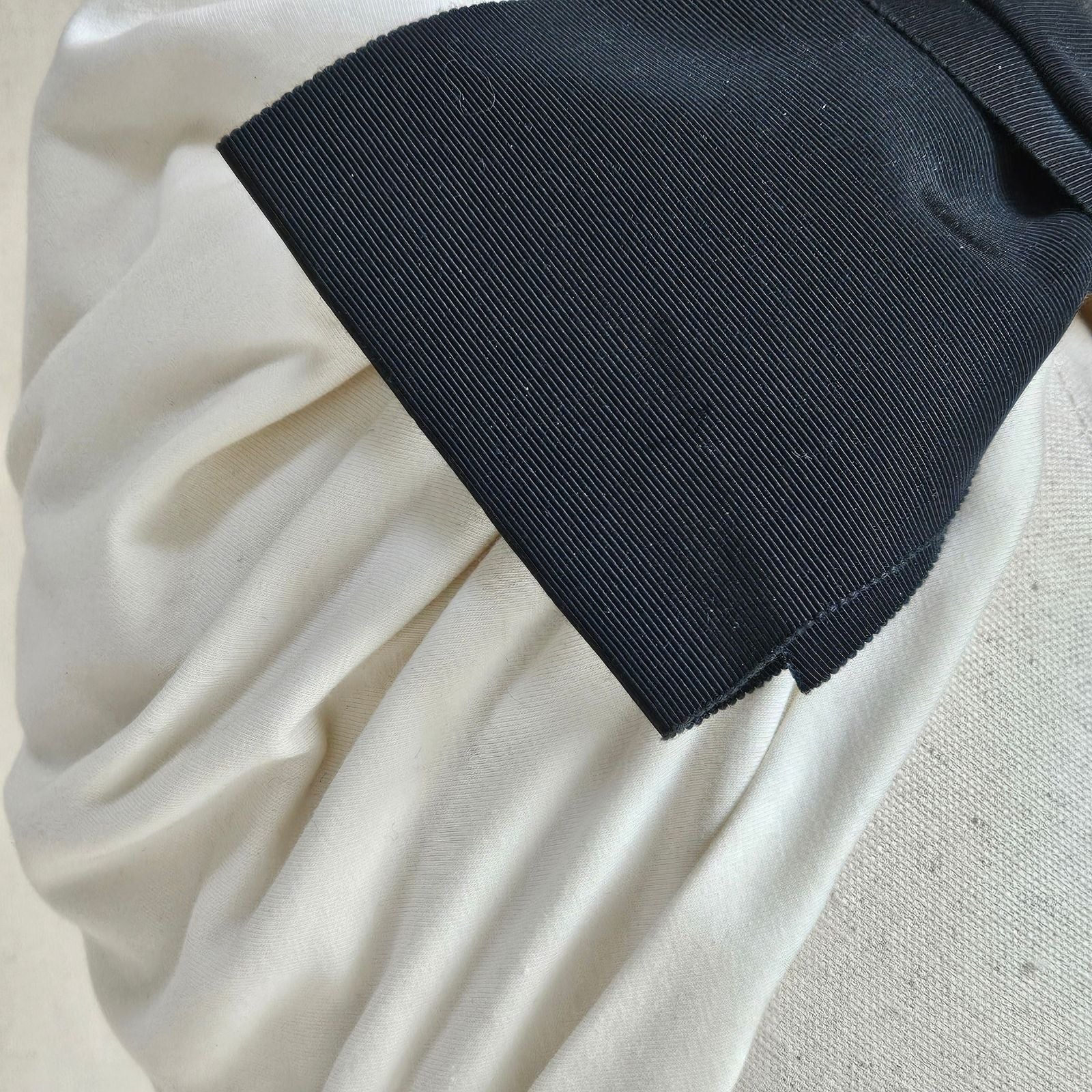 Detail of softly gathered ivory turban with dramatic black petersham bow.